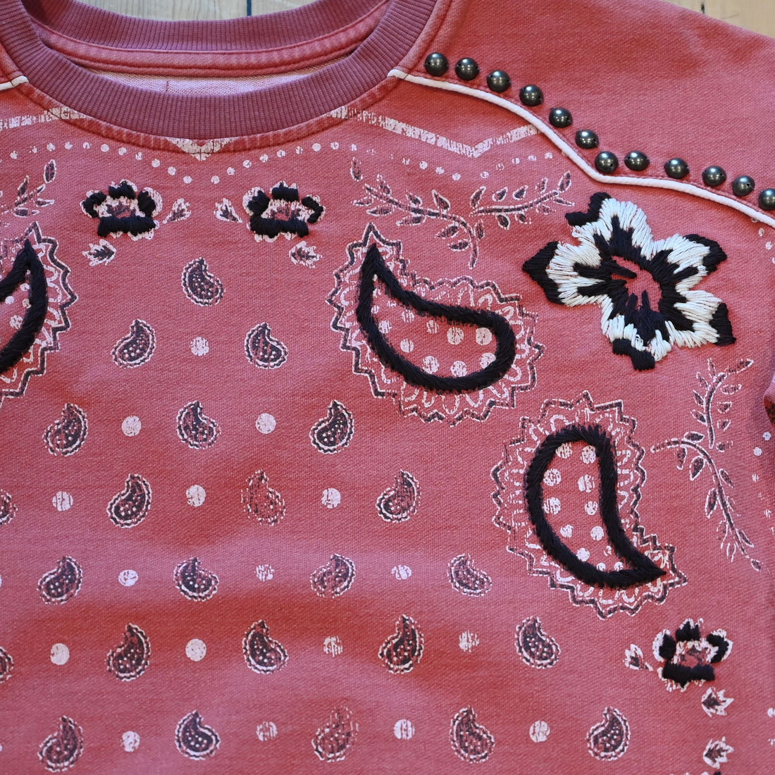 View of Ladies bandana sweatshirt in muted mahogany with embroidered and studded bandana print