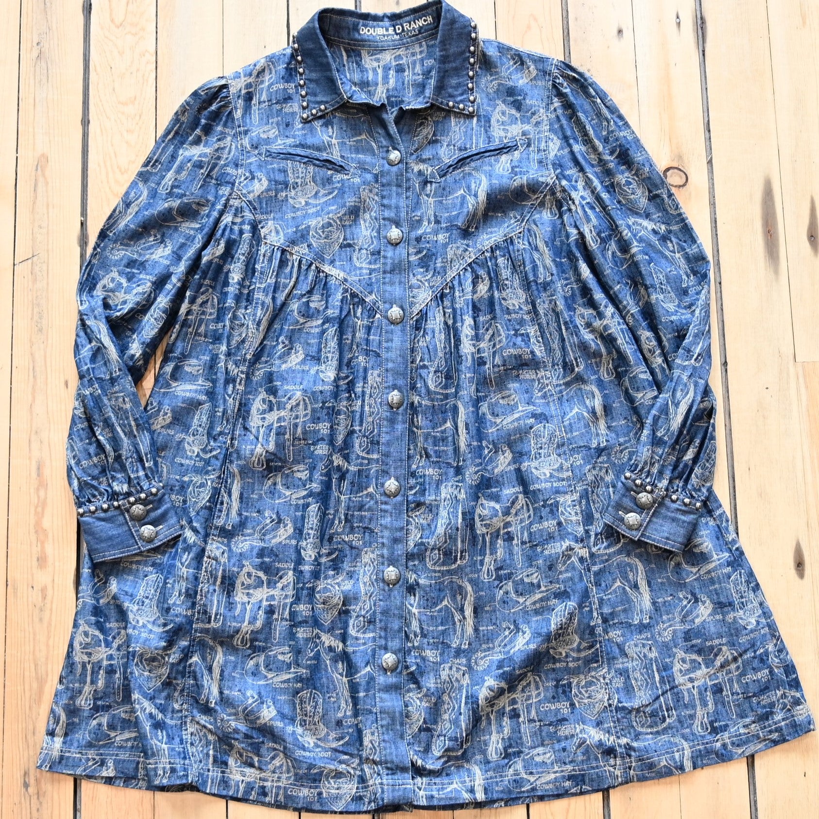 View of Double D Ranch Cowboy 101 Dress – Denim-inspired dress featuring cowboy motifs, silver studding, and concho buttons for a chic Western look
