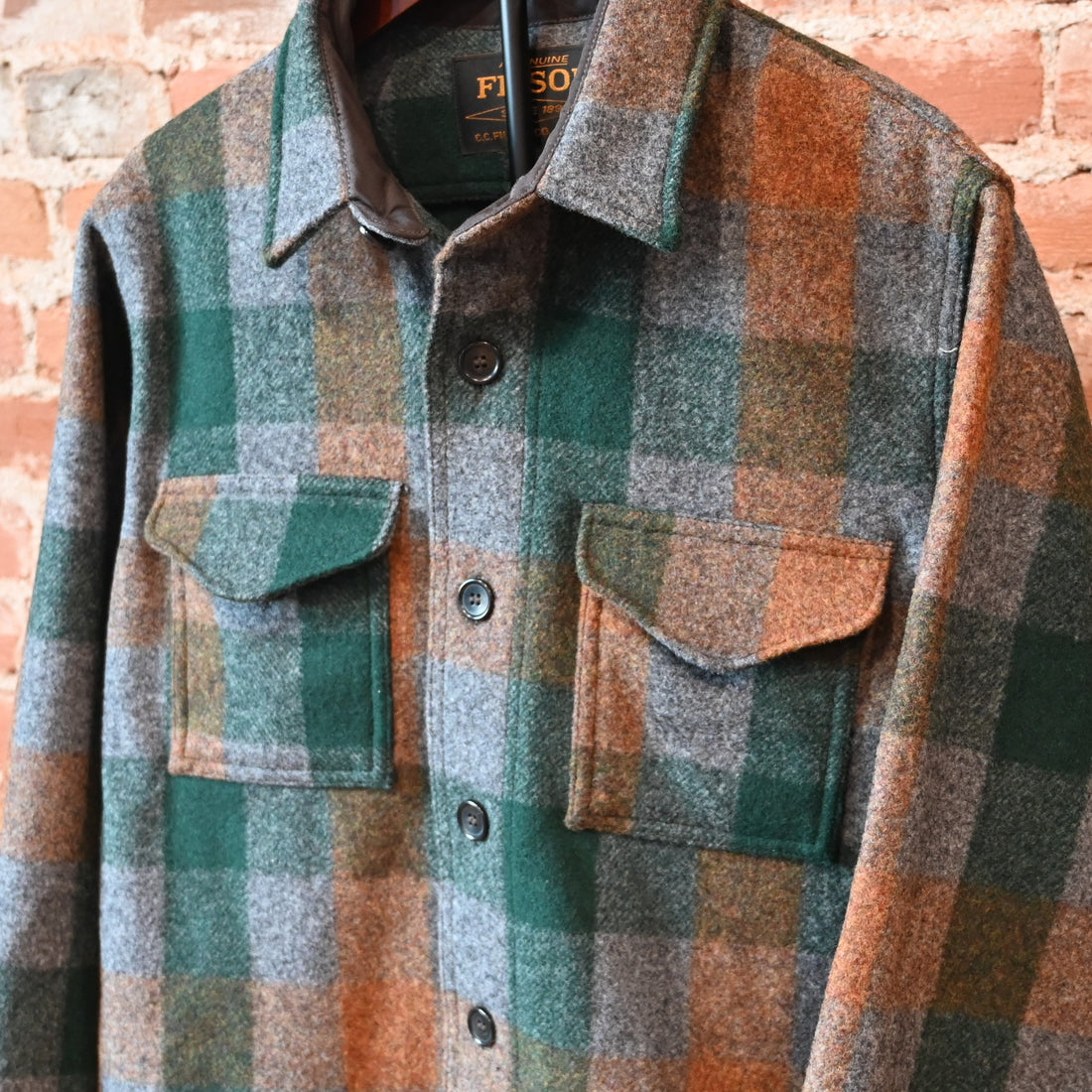Filson Mackinaw Wool Jac-Shirt in Green, Orange, and Gray Plaid with button-front and chest pockets