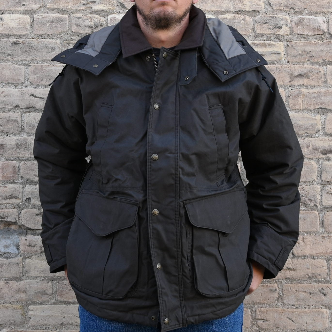 View of Filson Ranger Insulated Field Jacket in Root, showcasing dry-waxed cotton fabric, removable insulated hood, and multiple functional pockets