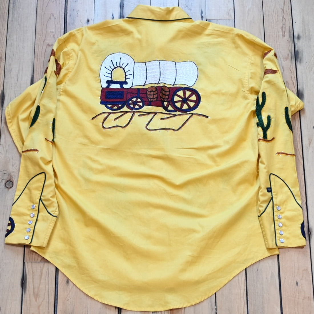 View of Rockmount men’s gold western shirt with wagon embroidery and sawtooth pockets