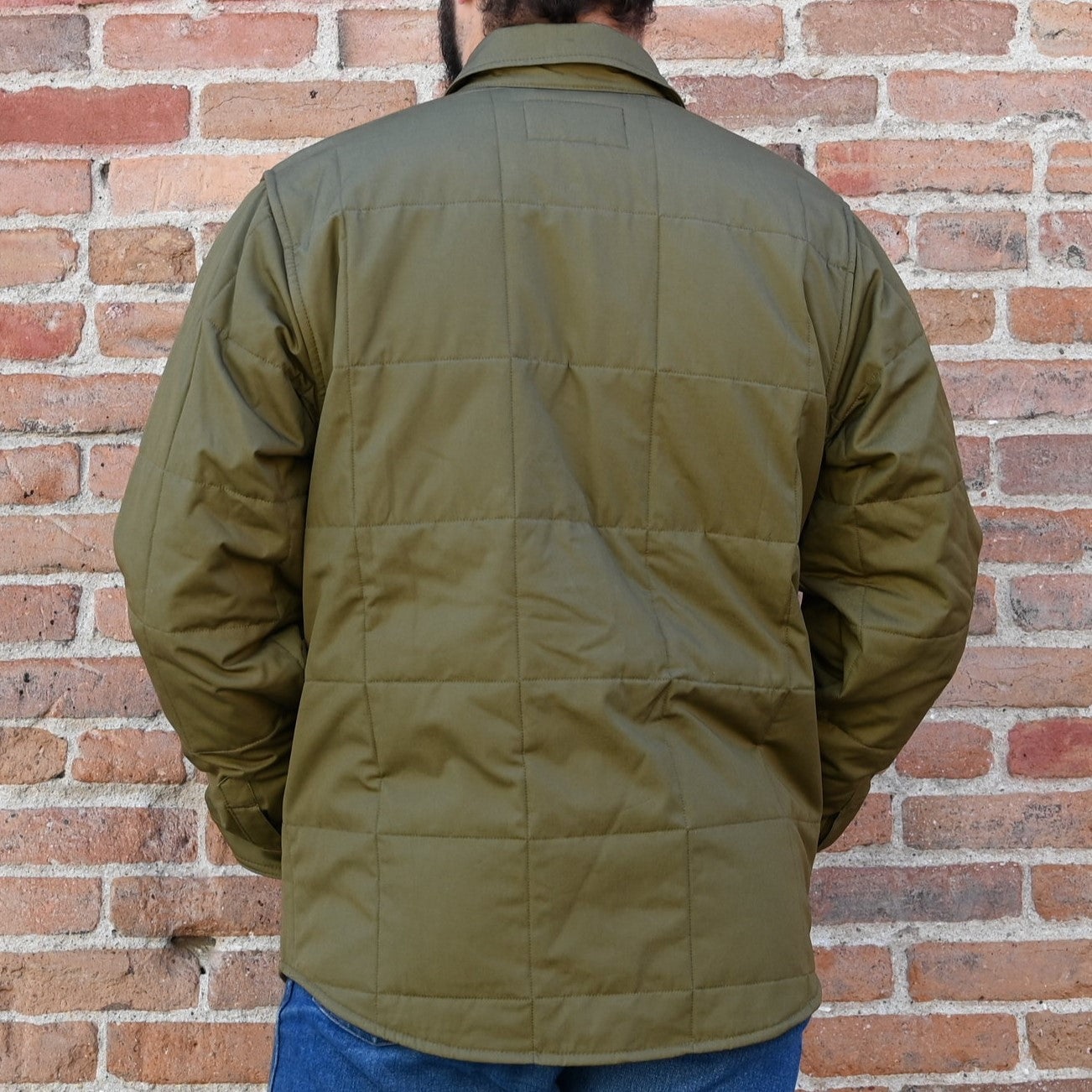 View of Filson Cover Cloth Quilted Jac-Shirt in Olive Drab and Cinder featuring snap-front closure, snap-flap chest pockets, and flannel-lined hand pockets