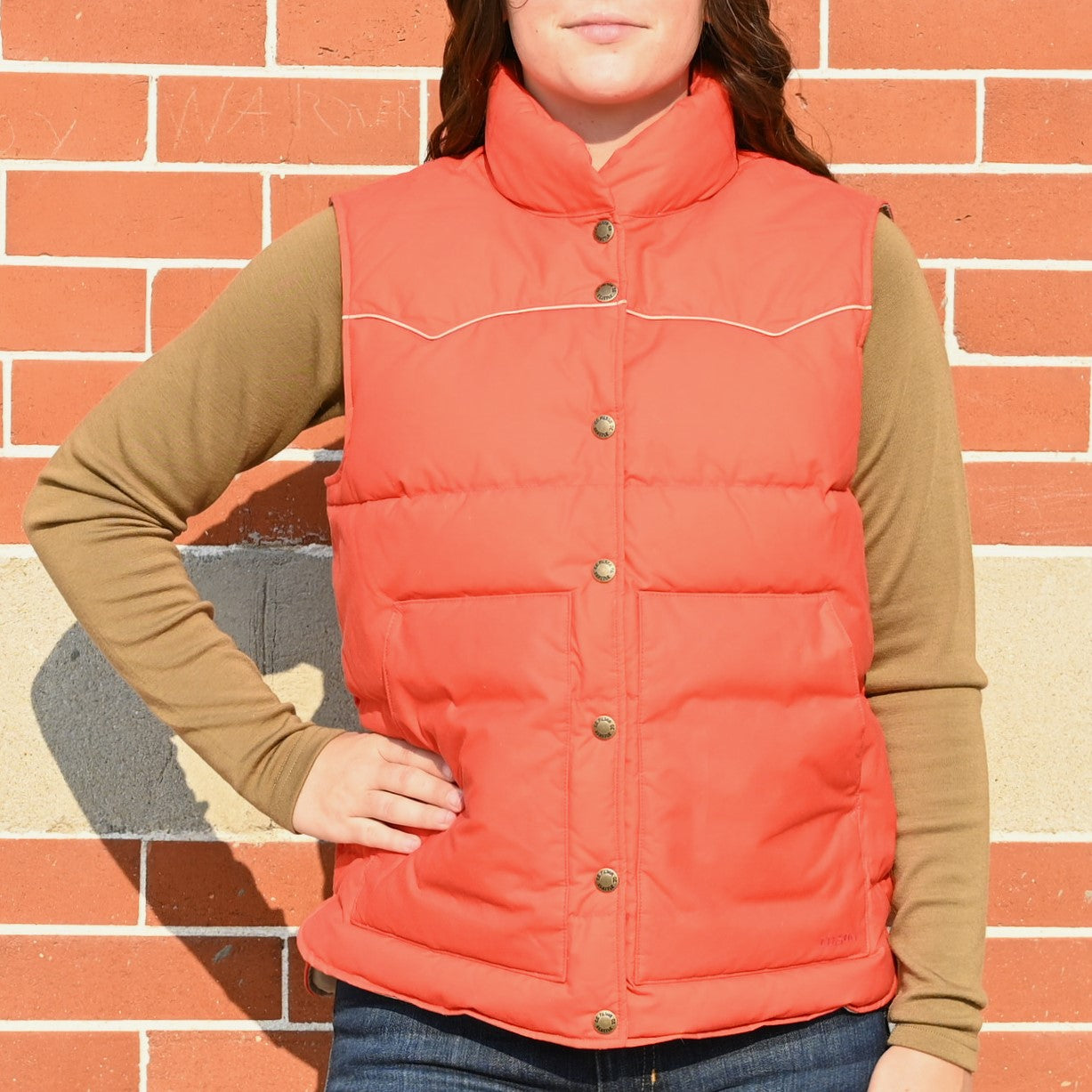 View of Filson Ladies Waxed Down Vest in Campfire featuring curved shoulder yokes and fleece-lined hand pockets