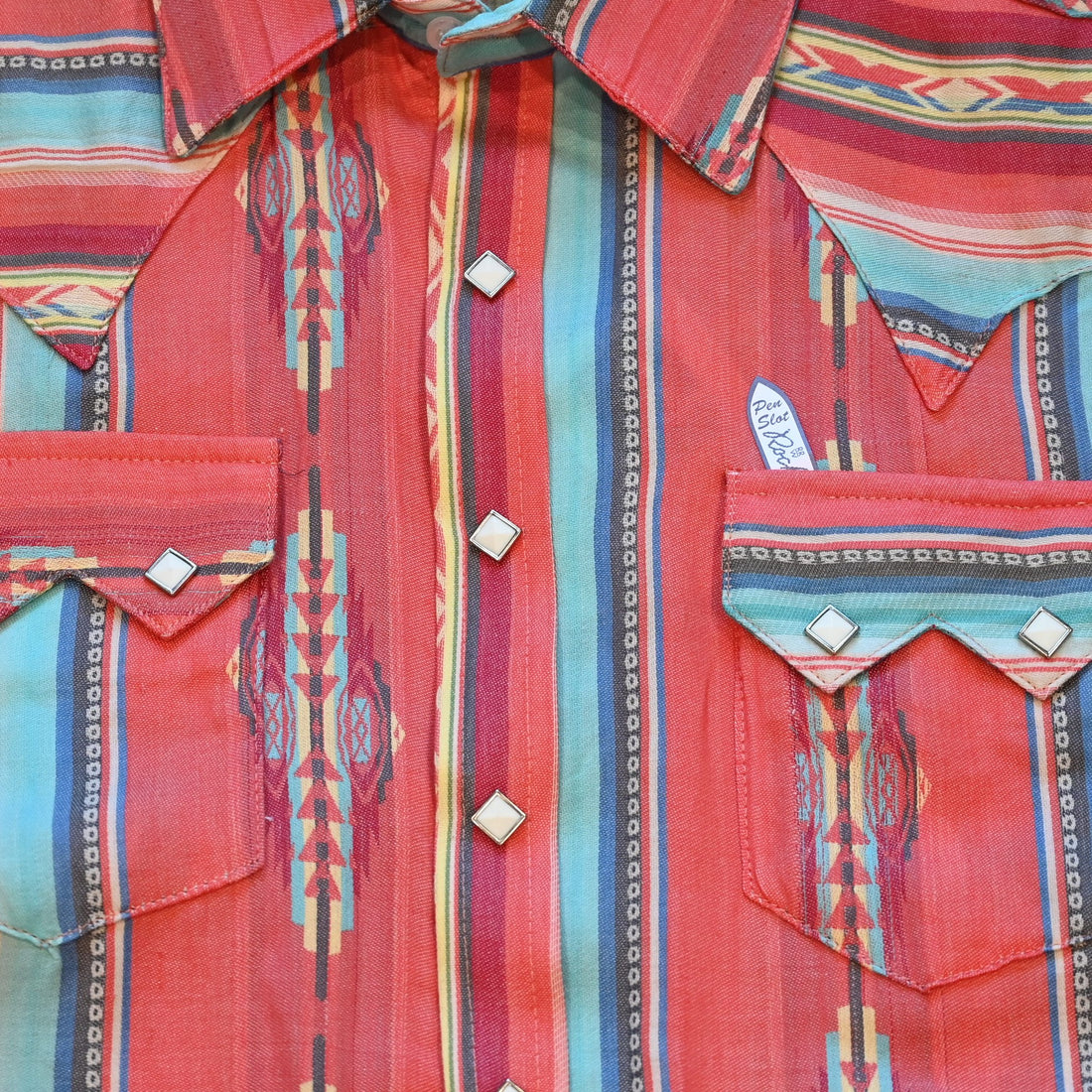 View of Rockmount men’s coral serape stripe western shirt with diamond snaps and sawtooth pockets