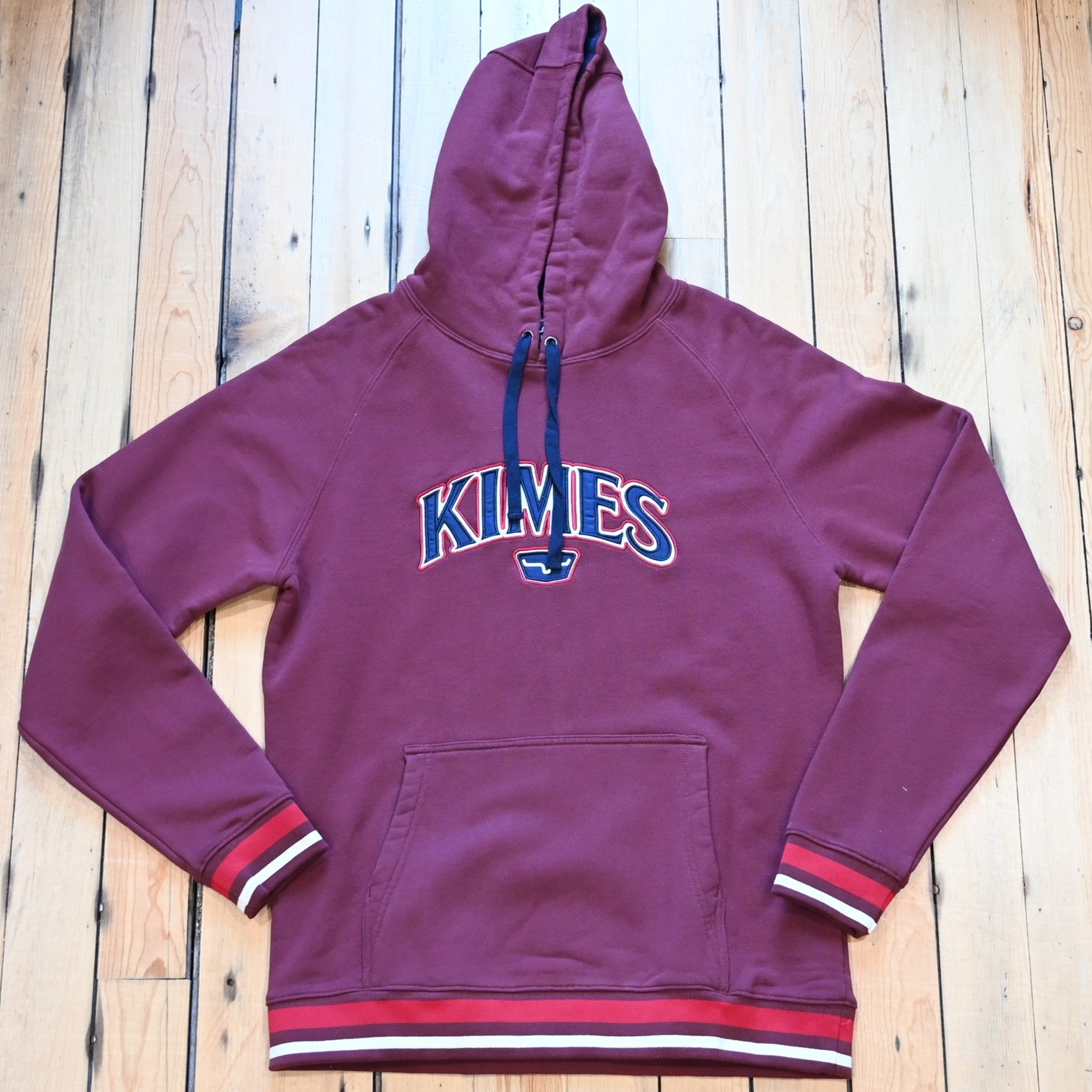 View of Kimes Ranch Kubo Sweatshirt in Burgundy, featuring a vibrant striped bottom and embroidered logo