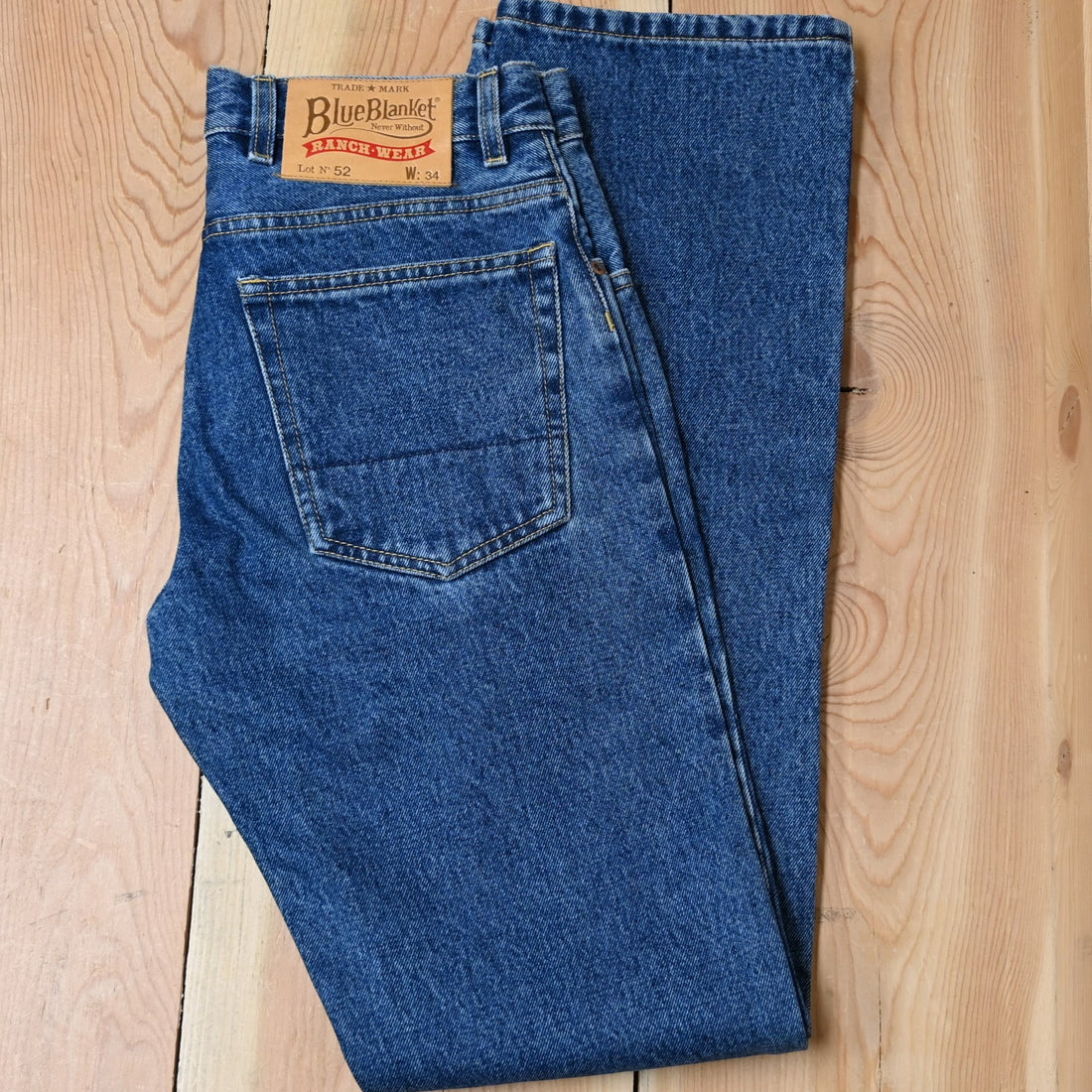 View of Blue Blanket men’s medium indigo straight-leg denim jeans with leather patch