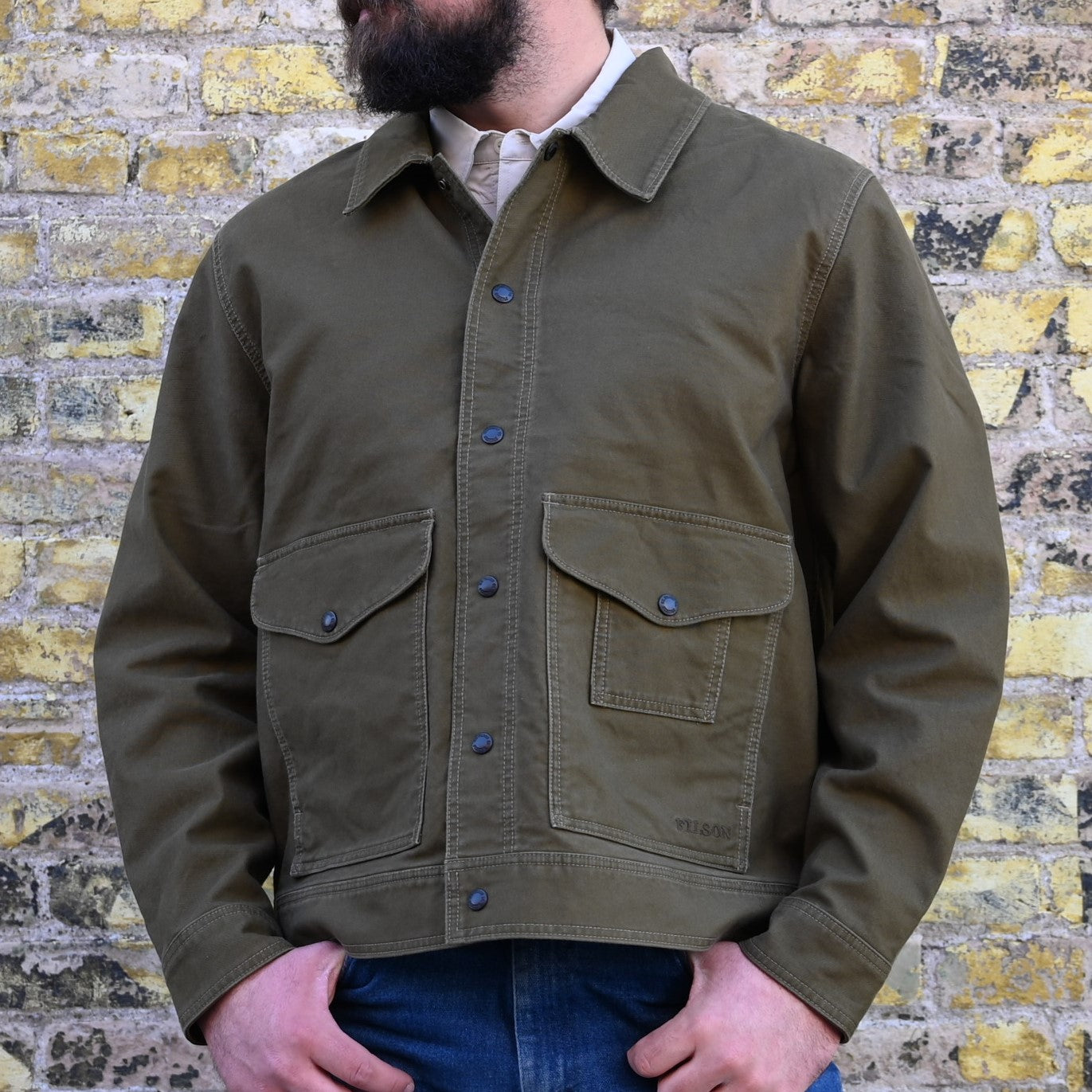View of Filson Jungle Cloth Work Jacket featuring snap-secure front, adjustable cuffs, and multiple pockets