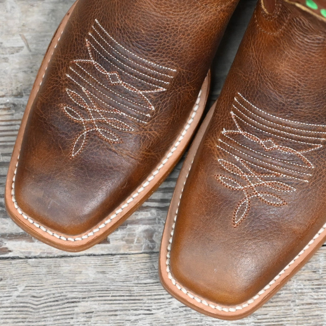 View of Hondo 16" cowboy boot with rust volcano top, red floral embroidery, rust oil tan vamp, and pull holes