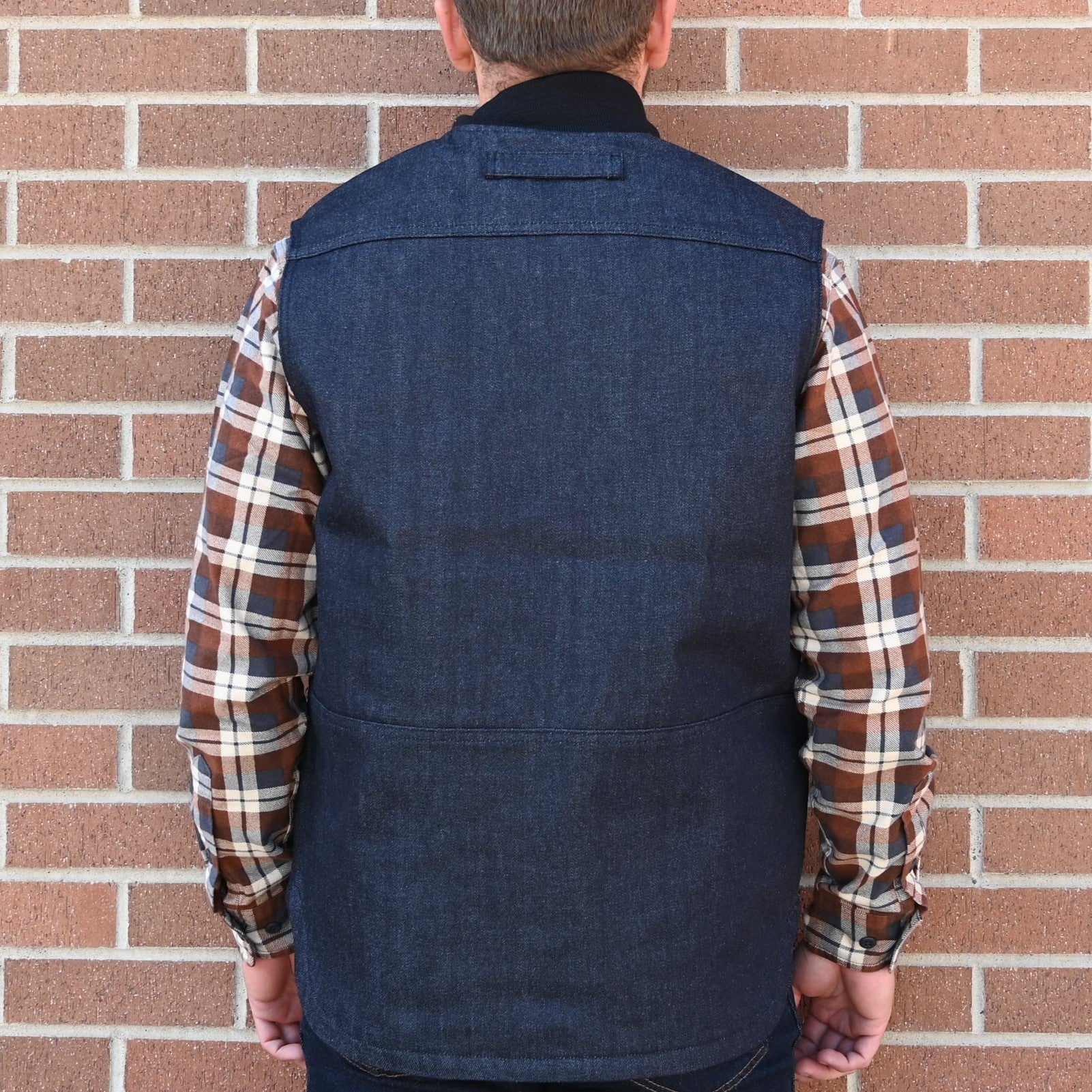 View of Filson Denim Insulated Work Vest in Raw Indigo featuring wool-blend rib-knit collar and four-pocket design