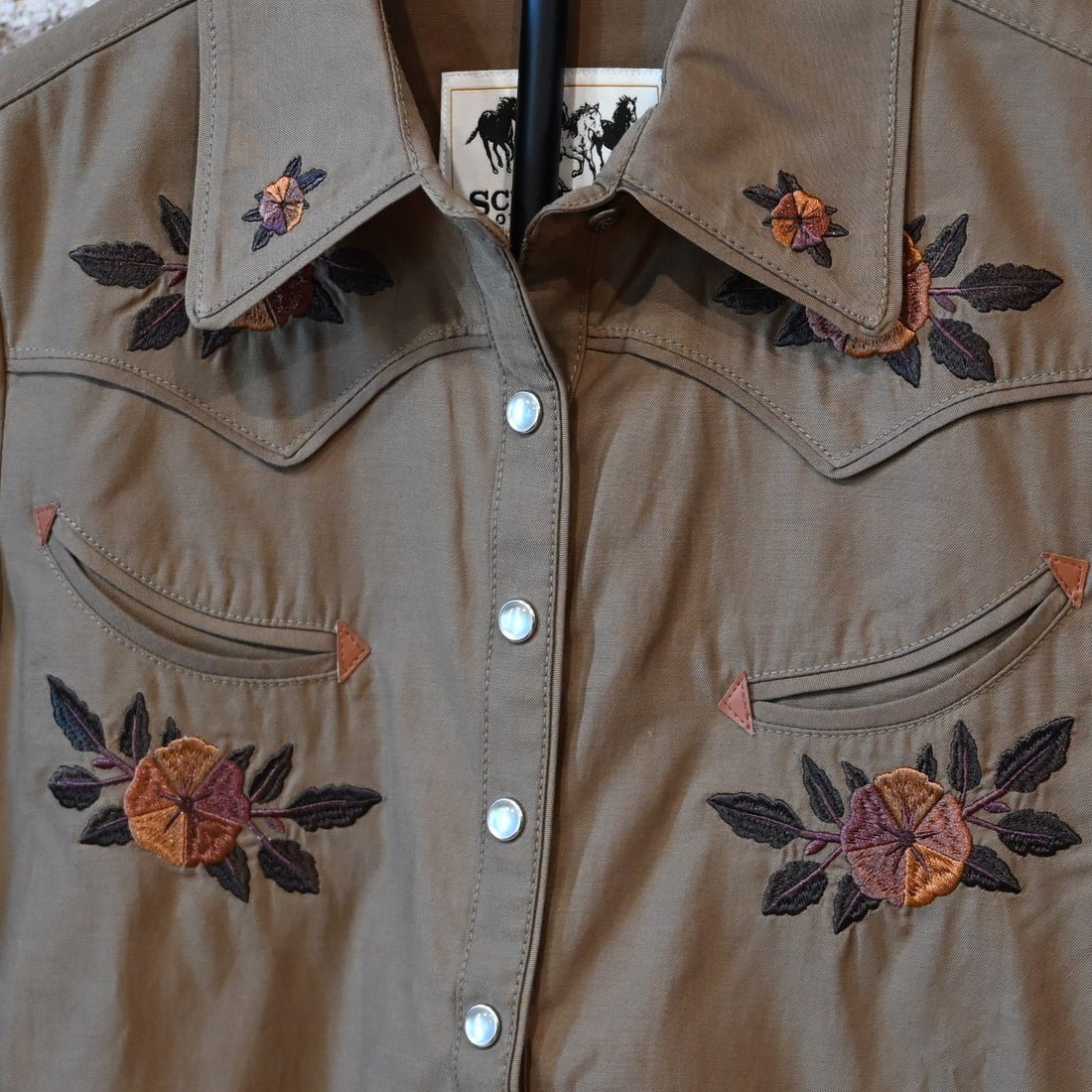 Schaefer Outfitter Ladies Embroidered Snap Shirt in chestnut with floral embroidery, leather-detailed pockets, and snap closures