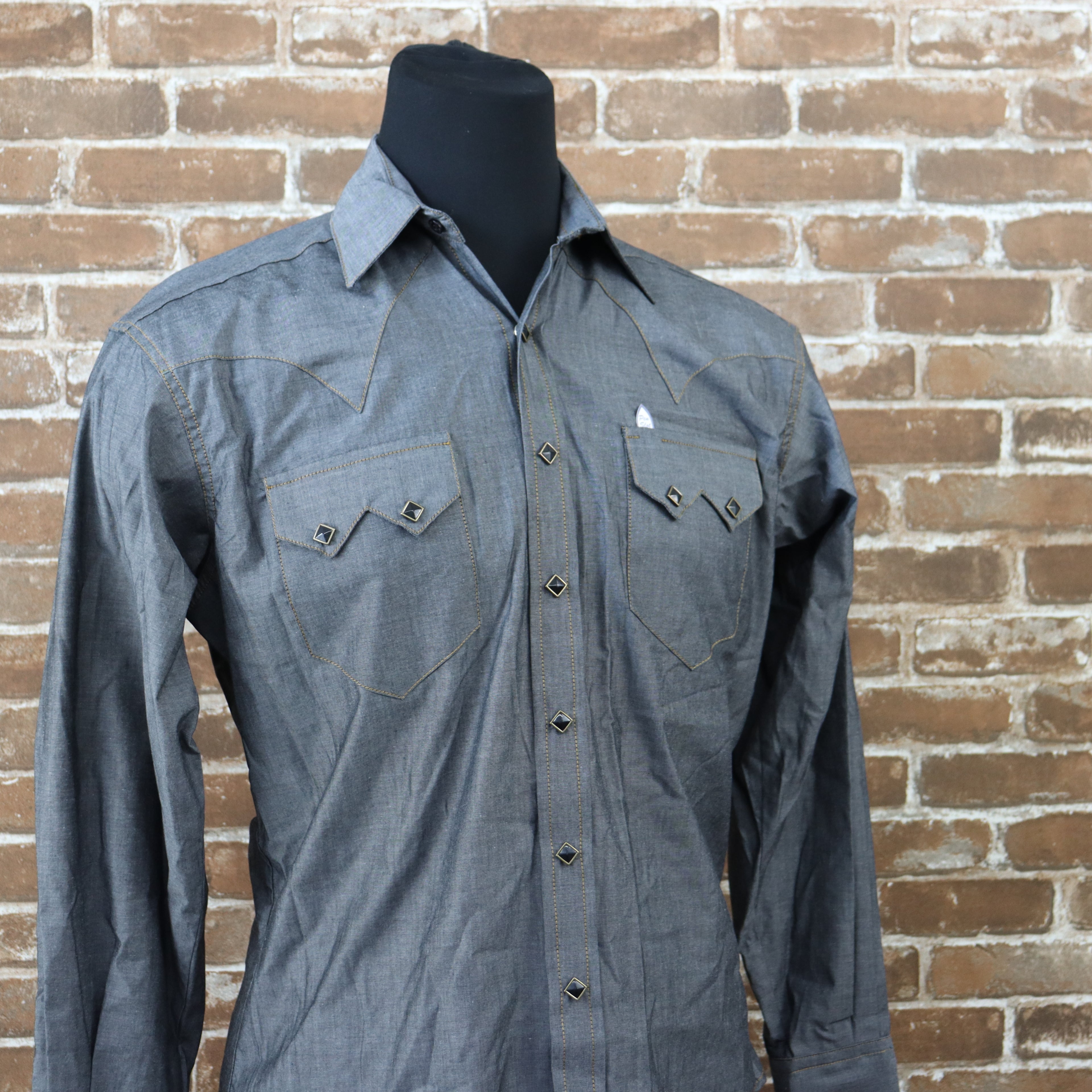 View of Rockmount black chambray western shirt with sawtooth pockets and gold diamond snaps