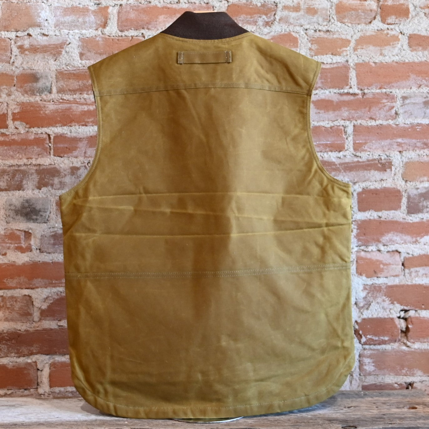 View of Filson Tin Cloth Insulated Work Vest in Dark Tan, showcasing durable Tin Cloth fabric and multiple functional pockets
