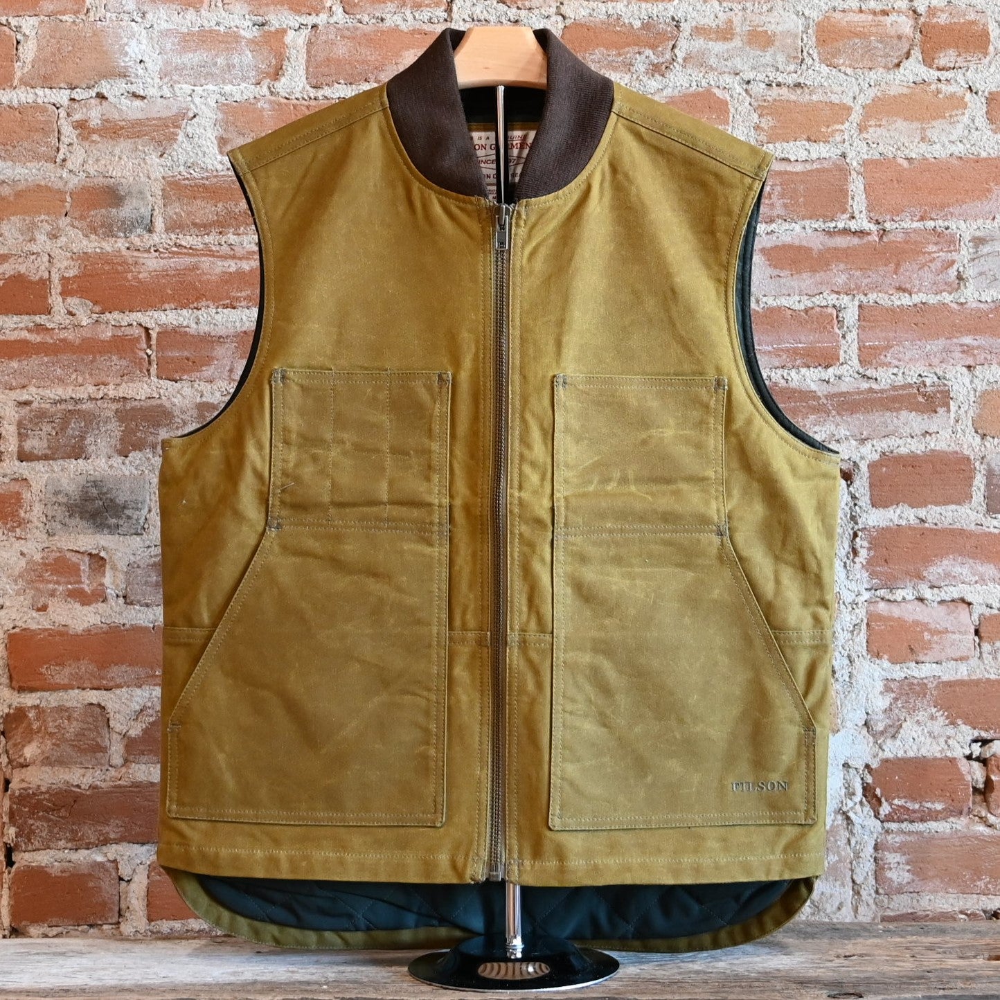 View of Filson Tin Cloth Insulated Work Vest in Dark Tan, showcasing durable Tin Cloth fabric and multiple functional pockets
