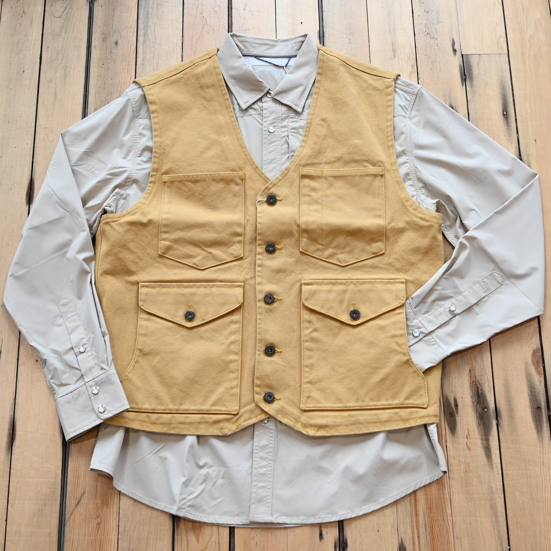 View of Schaefer brushcloth vest in suntan canvas with utility pockets and brass buttons