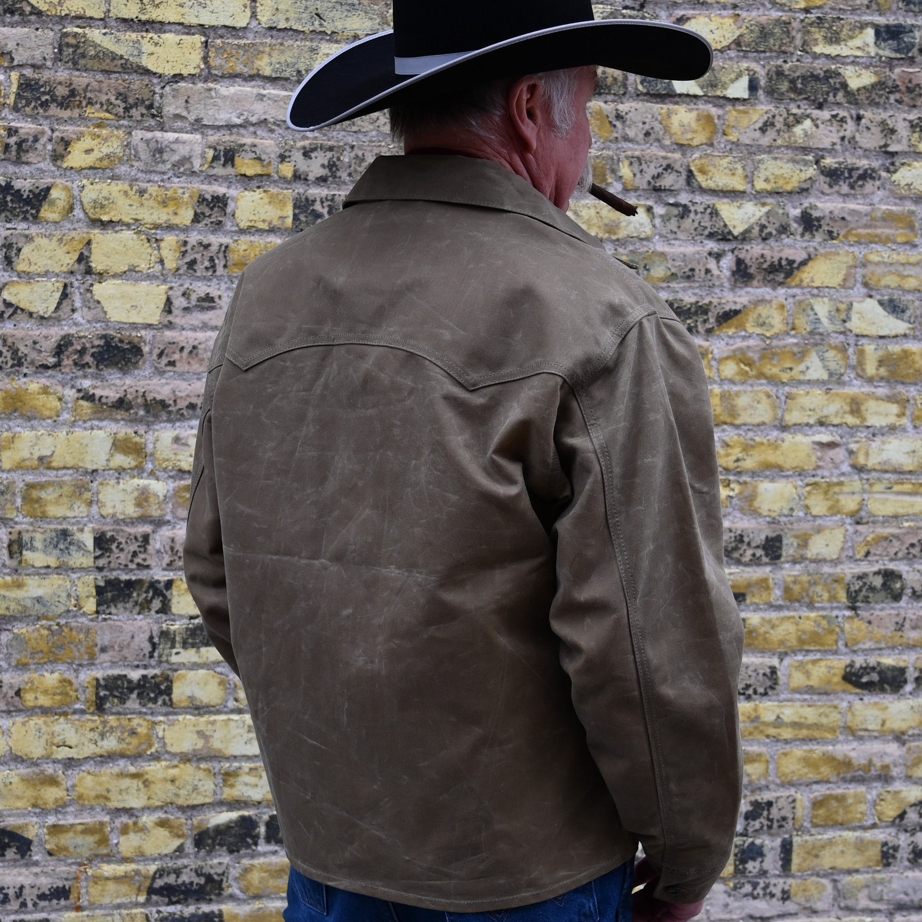 View of Schaefer ranch-style waxed cotton Mesquite Brush Jacket in oak or saddle with brass snap buttons