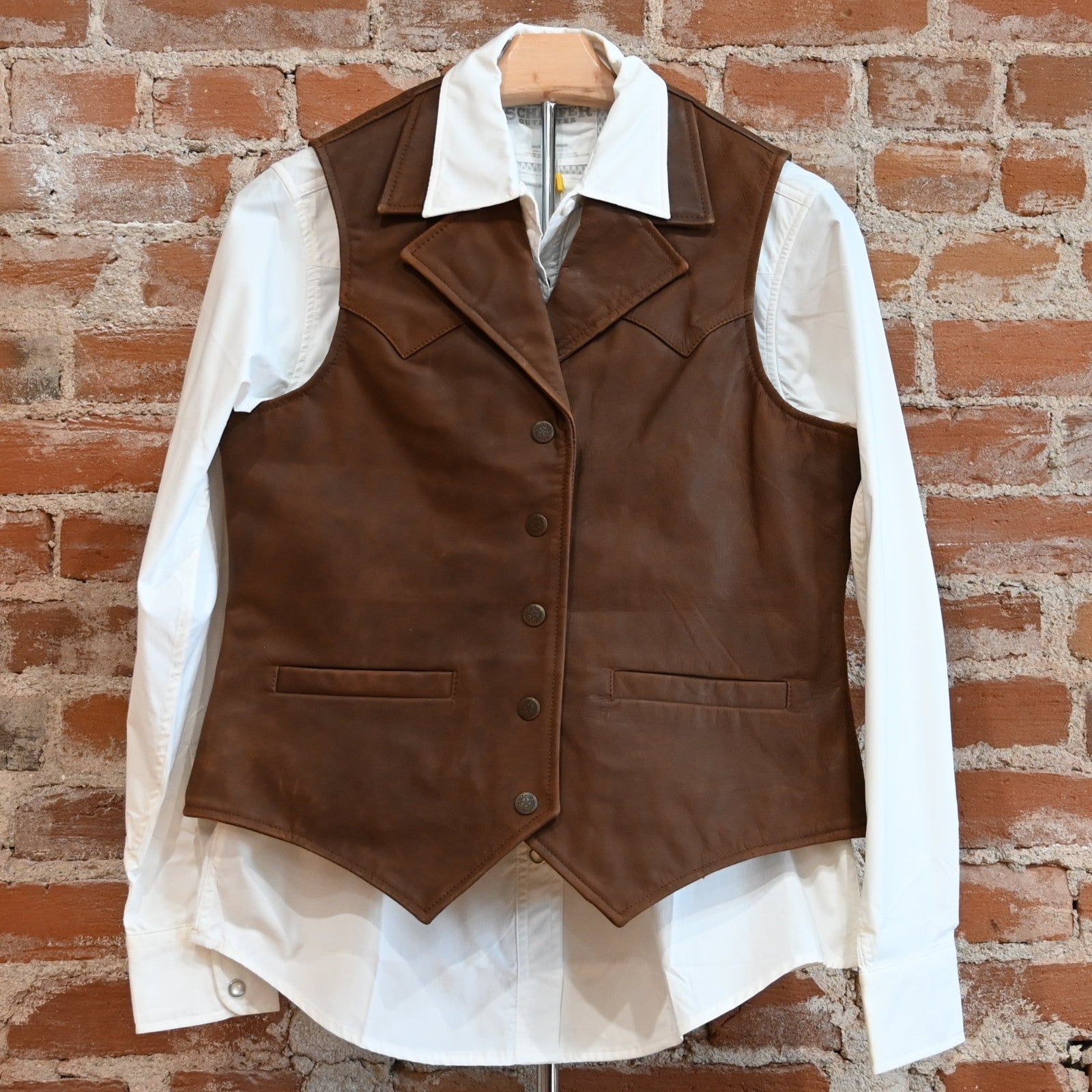View of Schaefer ladies whiskey leather vest with Western yoke, snap front, and interior pockets