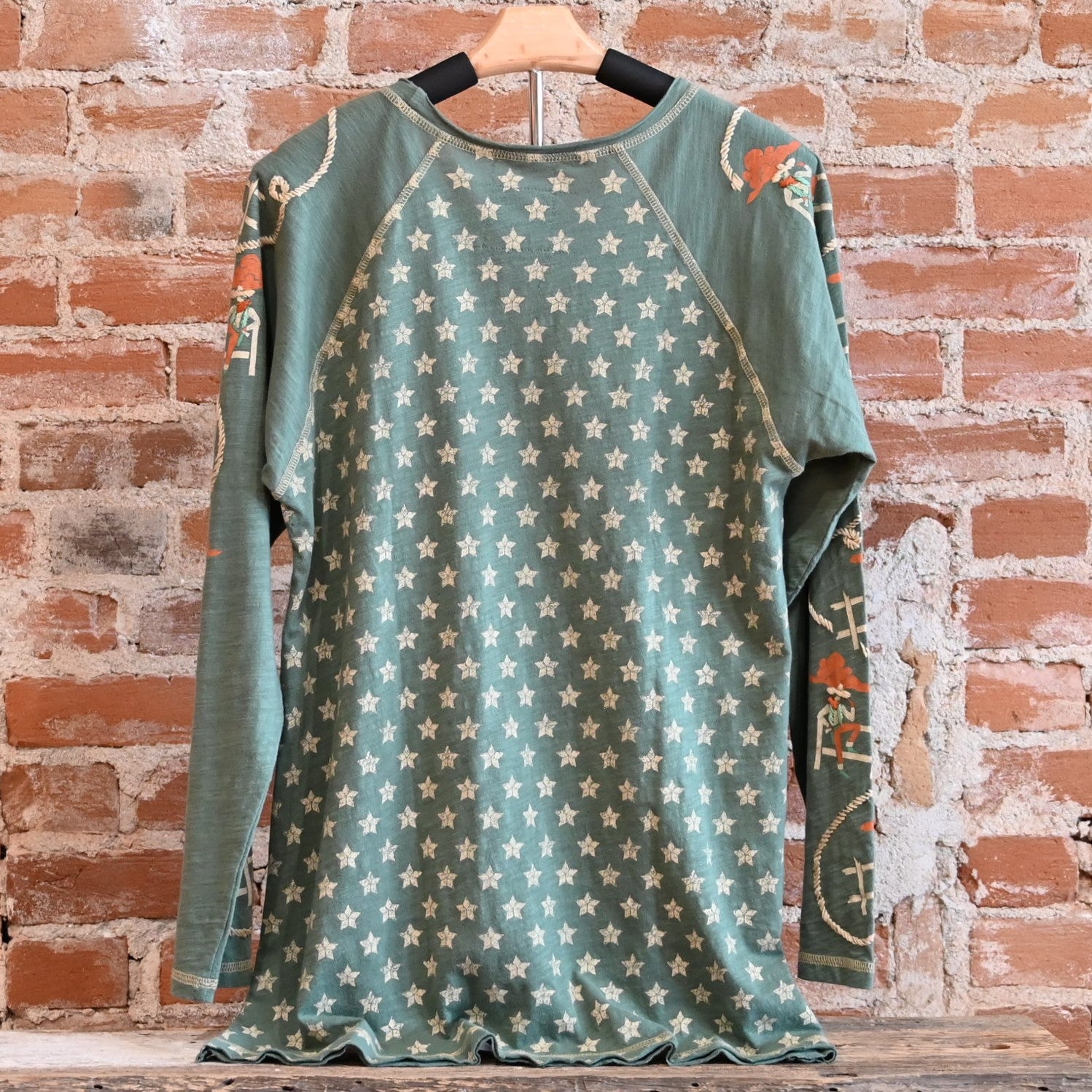 View of Double D Ranch Cowboys Up My Sleeve Top – Button-down top in Garcitas Green with cowboy-inspired print and a relaxed, flattering fit