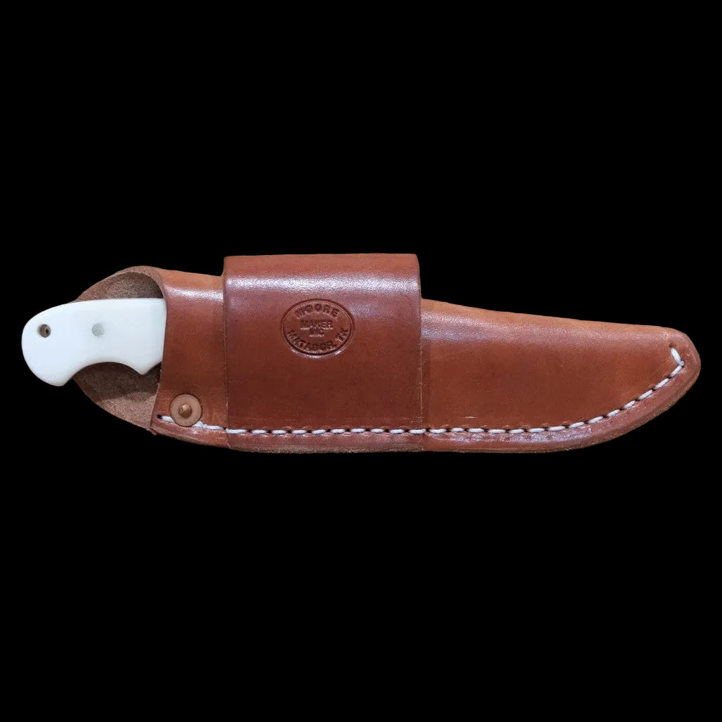 Moore Maker Hay Cutter knife with serrated blade and white bone handle next to its leather sheath.