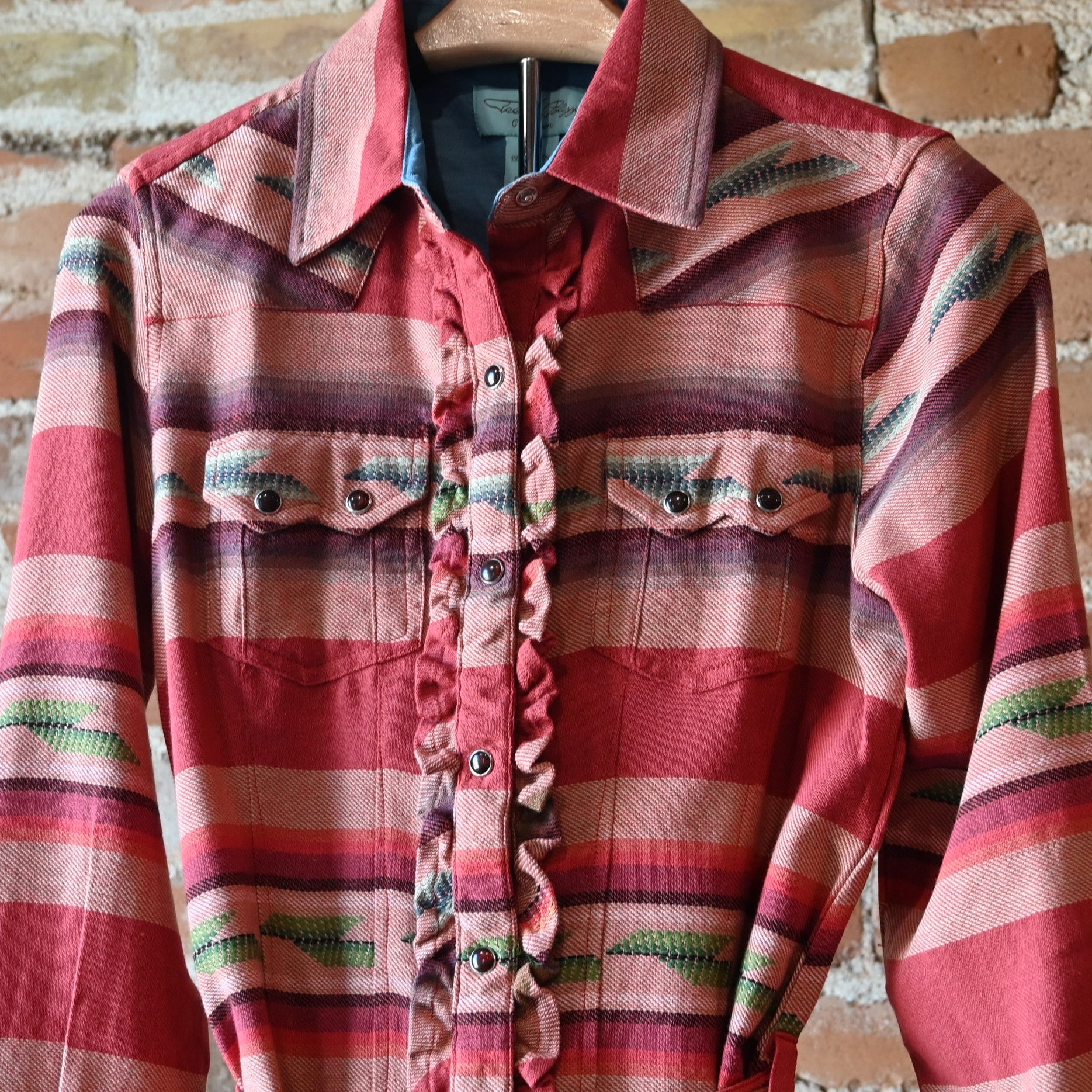 Ladies Colt 44 Tunic in rouge serape pattern with pearl snaps, self-tie belt, collar, and double breast pockets
