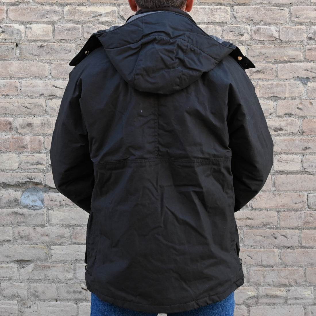 View of Filson Ranger Insulated Field Jacket in Root, showcasing dry-waxed cotton fabric, removable insulated hood, and multiple functional pockets
