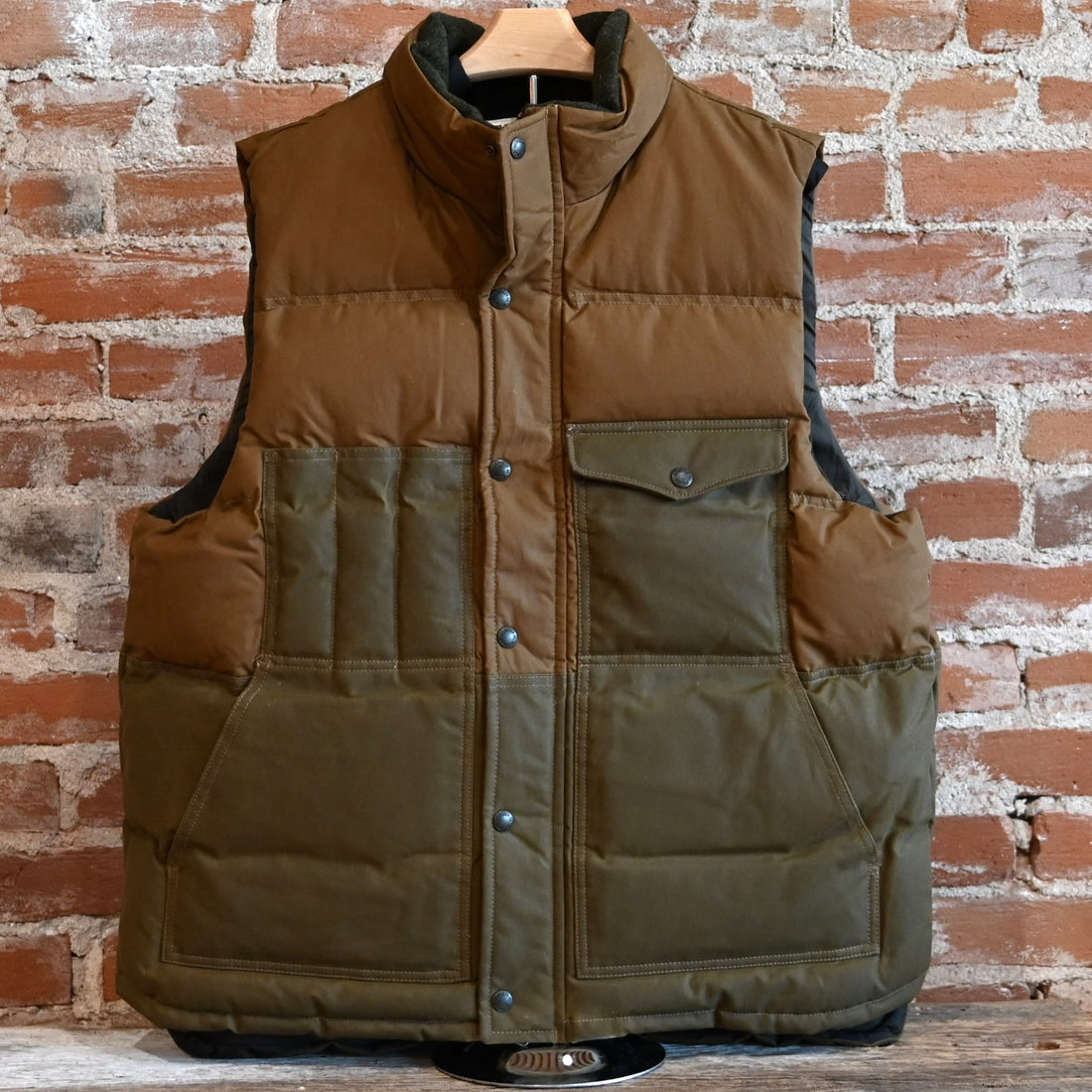 View of Filson Down Cruiser Vest in Dark Tan and Blue Coal featuring oil finish Cover Cloth and multiple pockets