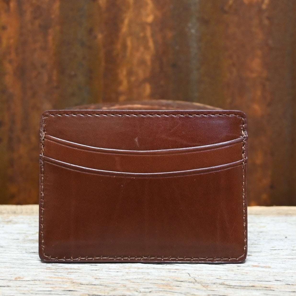 View of Lucchese sienna brown leather credit card case with sleek flat design and embossed logo