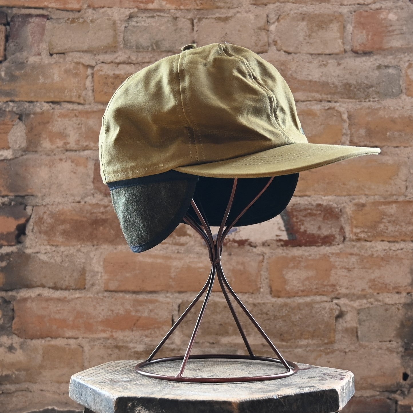 View of Filson Insulated Tin Cloth Cap in Dark Tan featuring wool ear/neck flap and 3" pre-curved bill