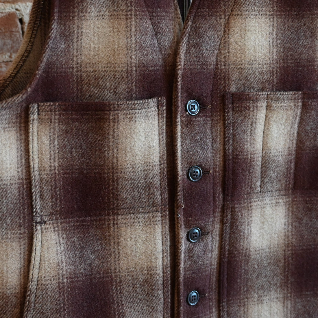 View of Filson Mackinaw Wool Vest in Brown/Tan Ombre featuring V-neckline, button-front closure, and multiple pockets