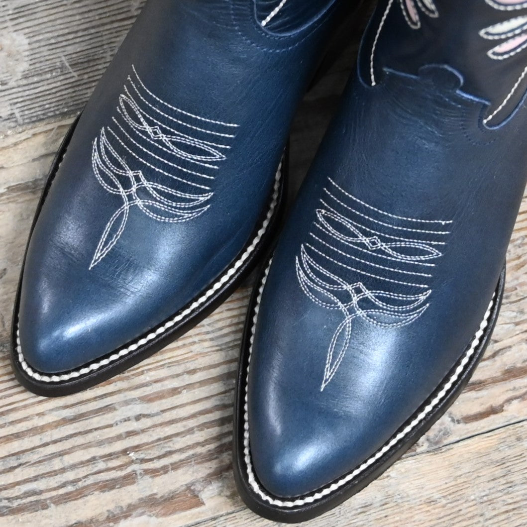 View of Macie Bean 10″ boot with navy glazed cowhide, berry inlays, almond toe, and cowgirl heel