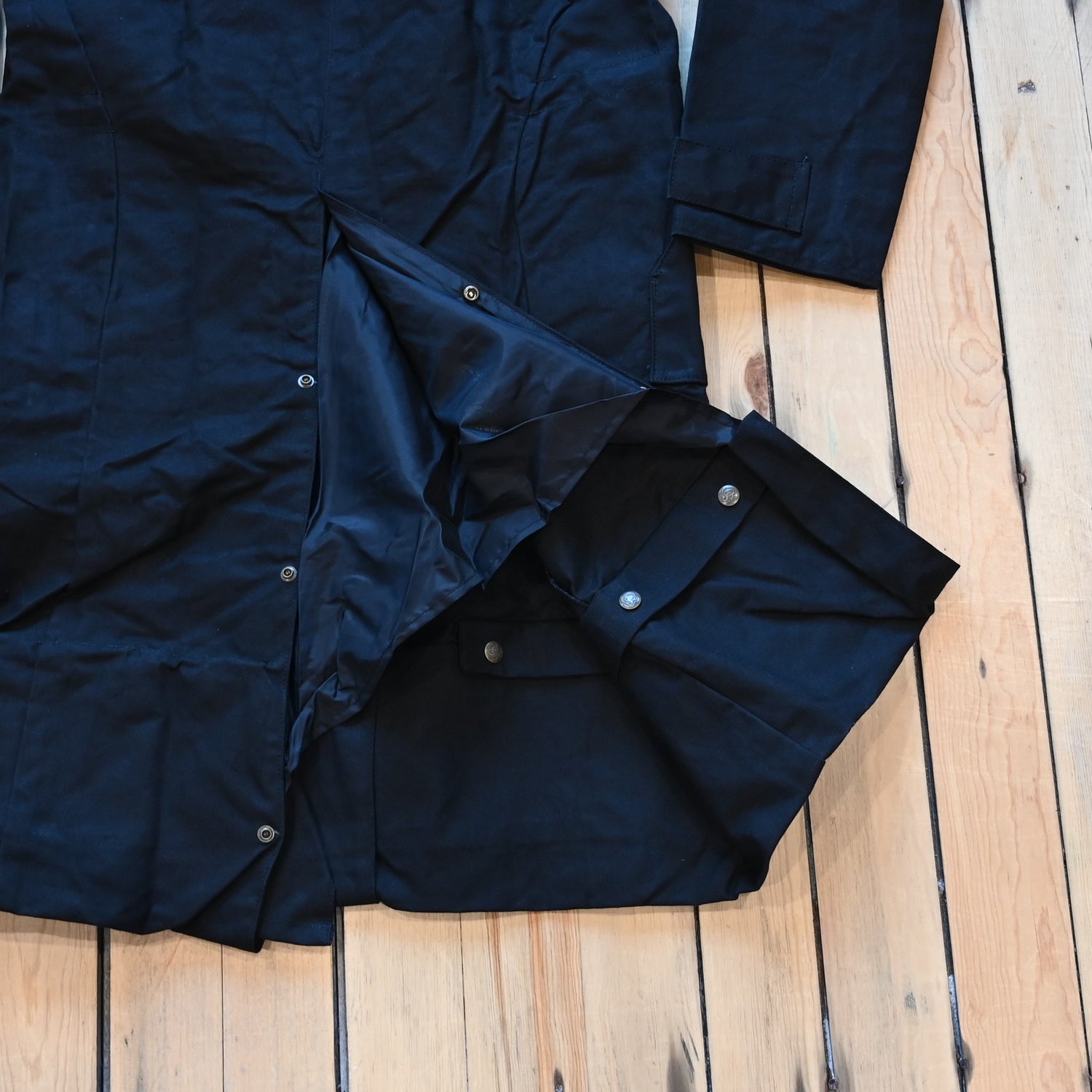 View of Black full-length Schaefer canvas duster coat with utility pockets and corduroy collar