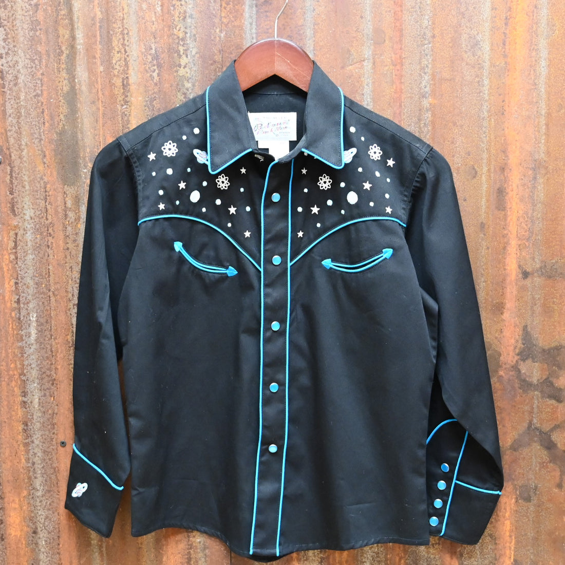 View of Black Rockmount kids western shirt size Large with embroidered stars, planets, and rockets