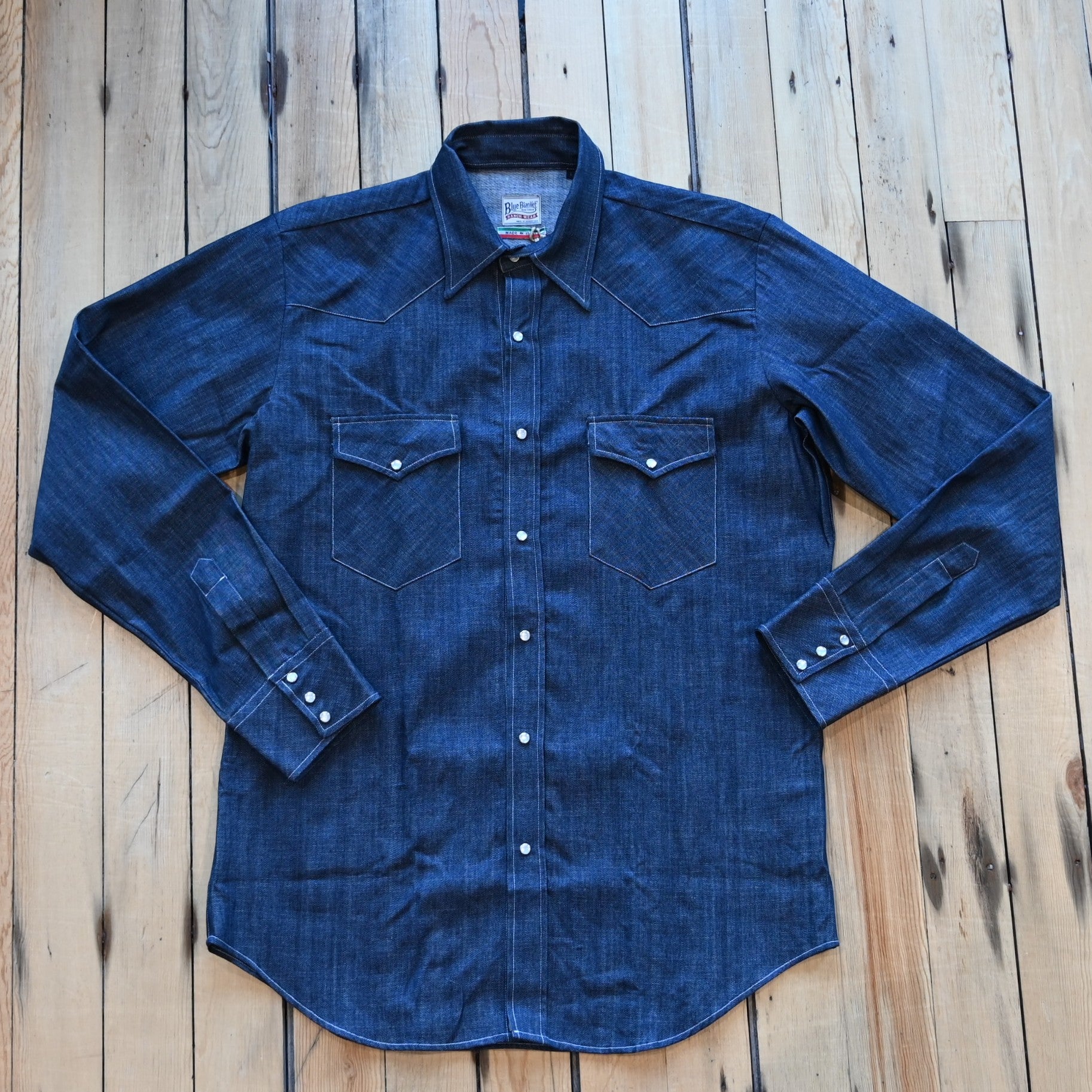 View of Blue Blanket men’s dark indigo denim Western shirt with pearl snap closures and yoke detailing