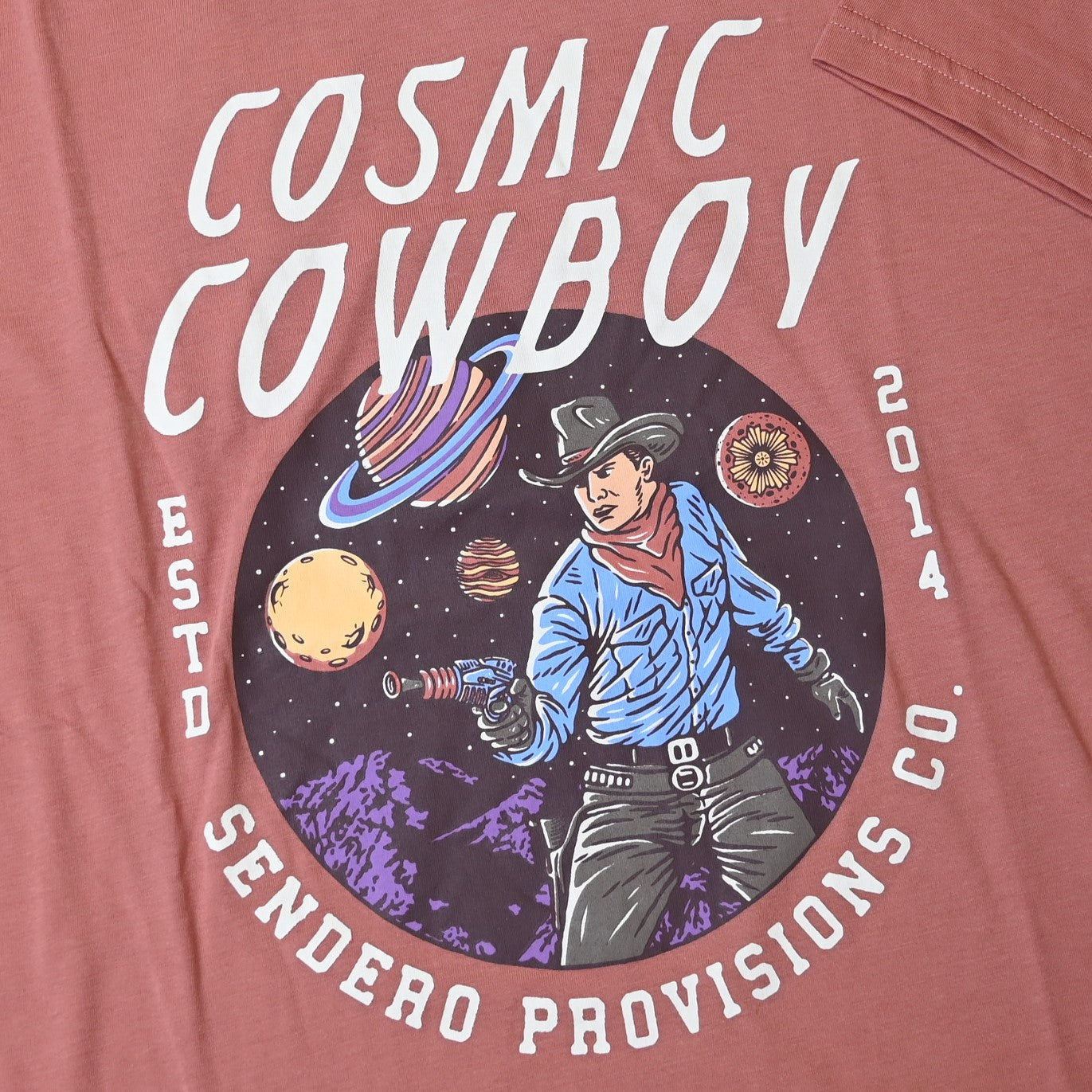 View of Sendero dusty mauve crop tee with cowboy floating in space and planets graphic
