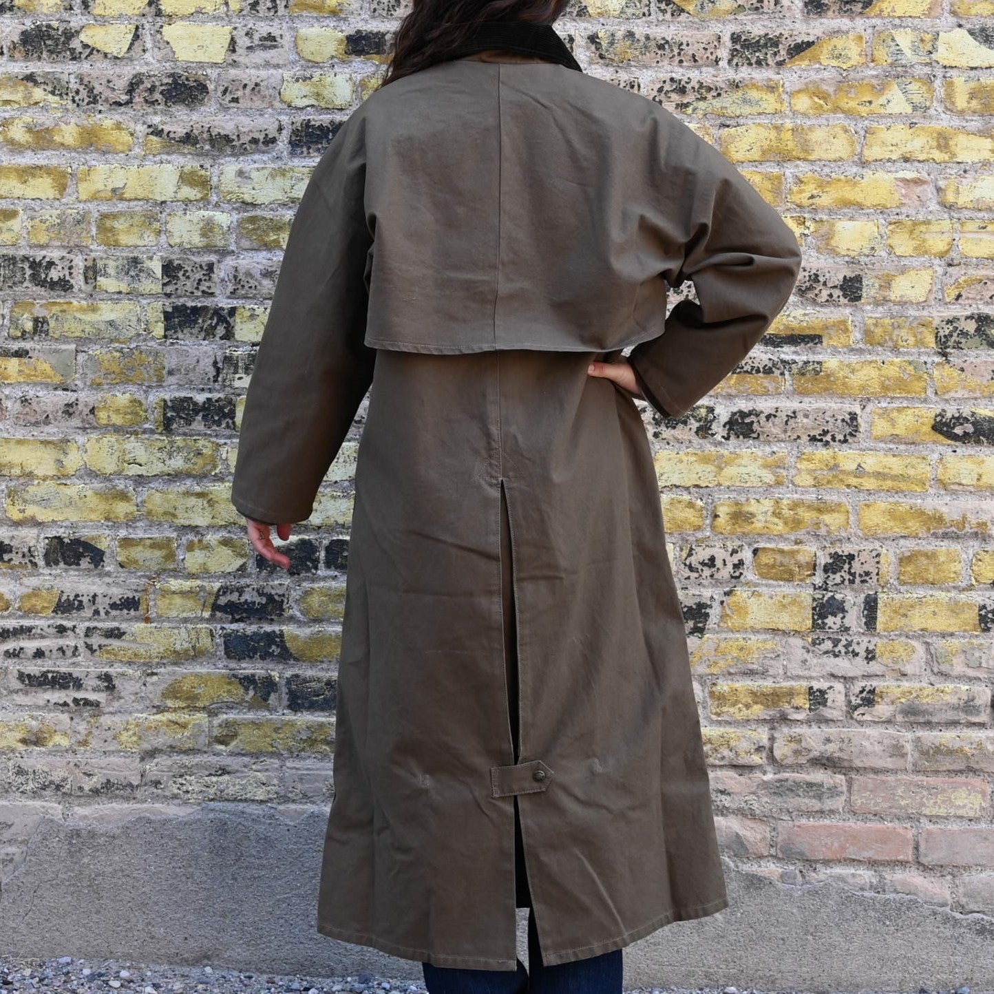 View of Filson Ladies Duster Coat in Marsh Olive featuring cape over shoulders, four front cargo pockets, and corduroy-lined collar