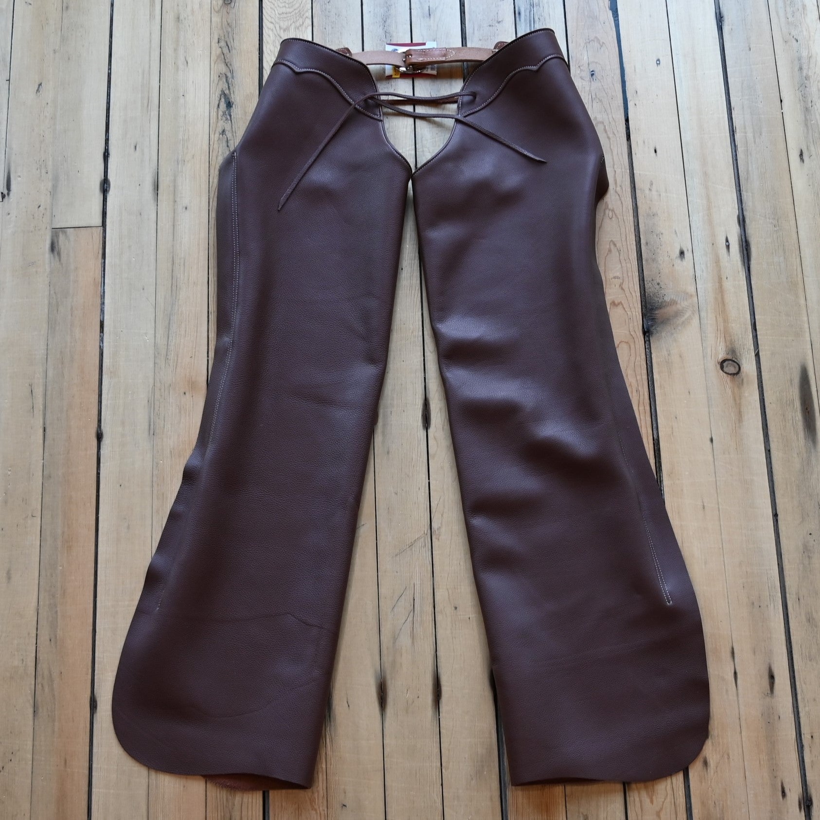 View of Weaver Shotgun Full Grain Chaps in brown oil-tanned leather with adjustable closures
