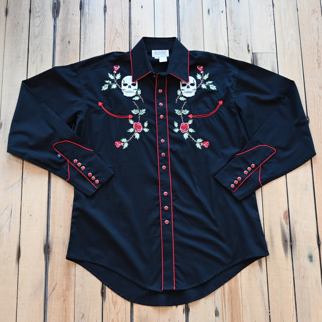 View of Black Western shirt with skull and rose embroidery and red piping