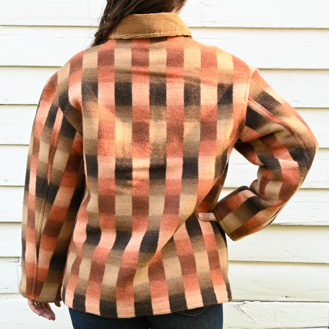 View of Filson ladies blanket wool barn coat in sunset ombre featuring snap-secure pockets and a cozy wool blend