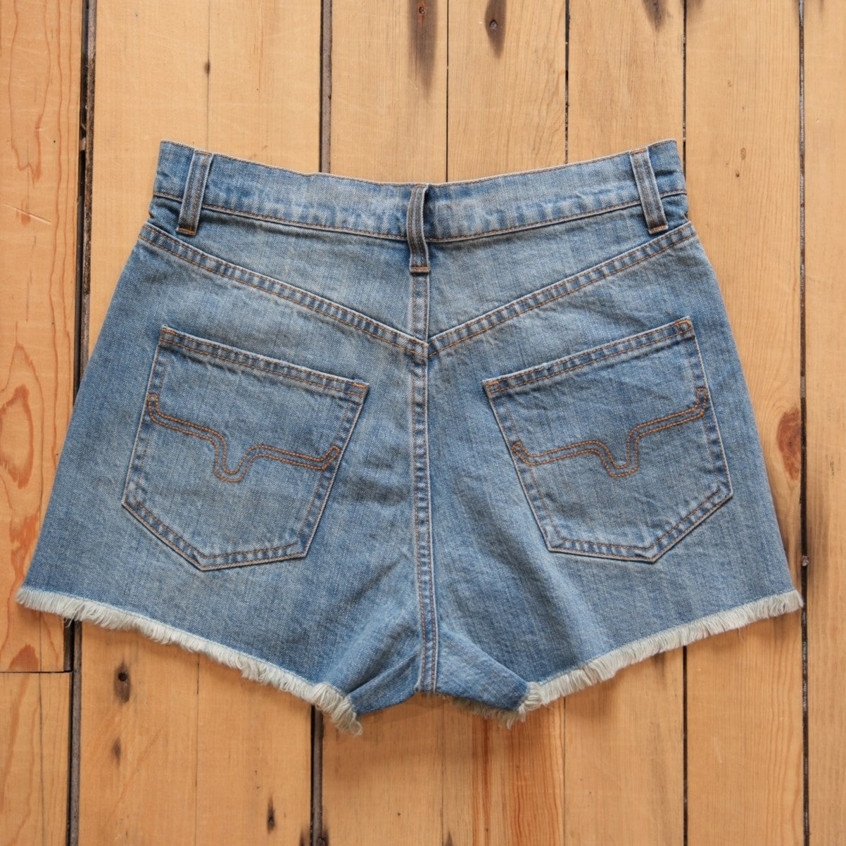 Kimes Ranch Daisy high-rise denim shorts in medium wash with raw hem.