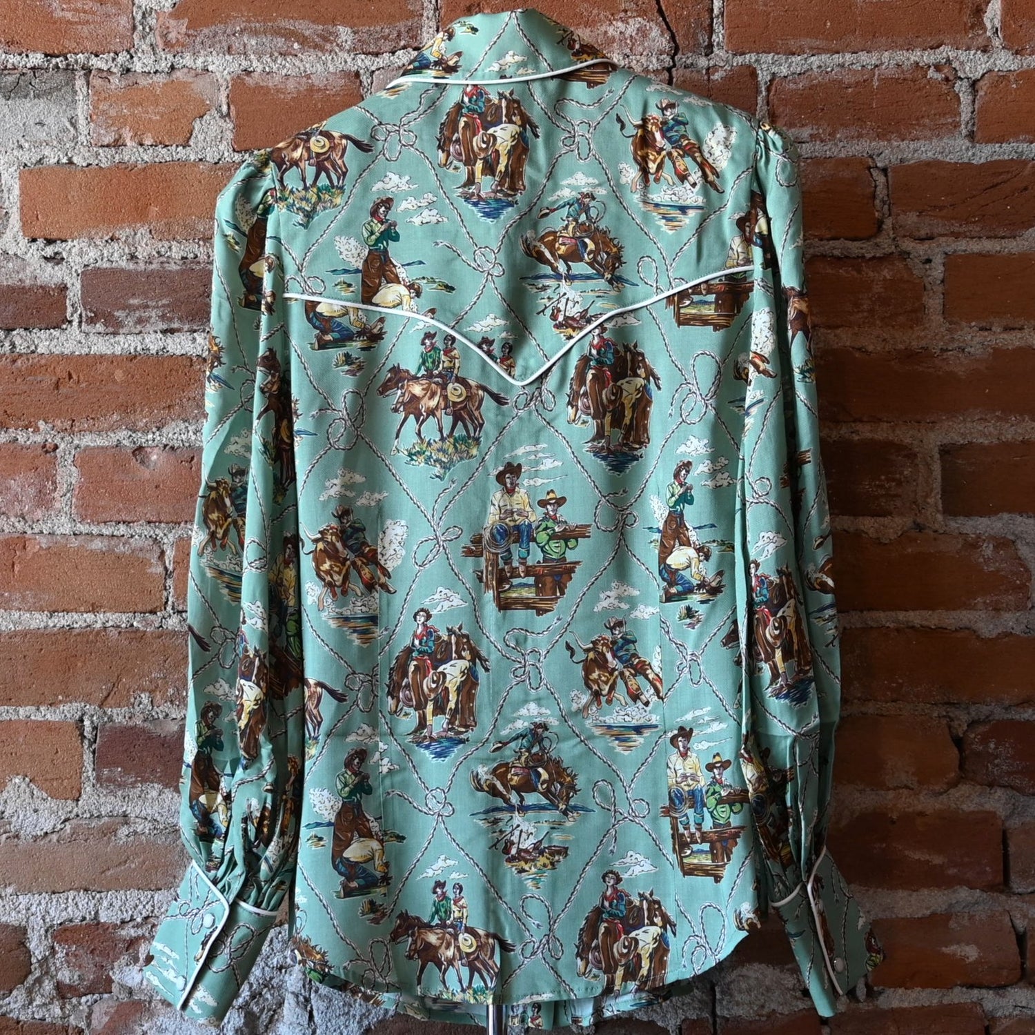 Ladies Romance &amp; Rustlers Top by Double D Ranch with mint-green pulp-art print, pearl snaps, contrast piping, and full cuffed sleeves