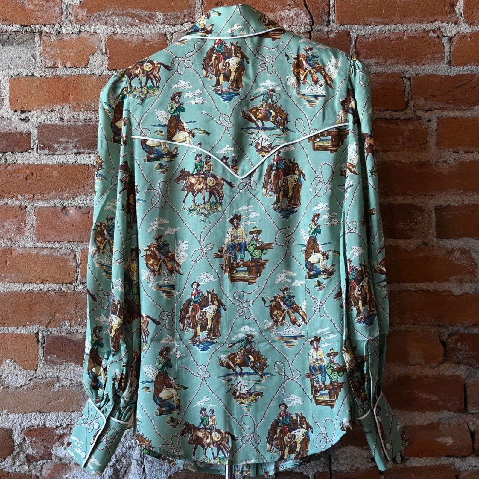Ladies Romance &amp; Rustlers Top by Double D Ranch with mint-green pulp-art print, pearl snaps, contrast piping, and full cuffed sleeves