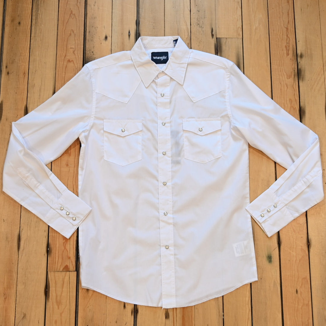 View of Wrangler men’s white Western snap shirt in broadcloth with yokes and flap pockets