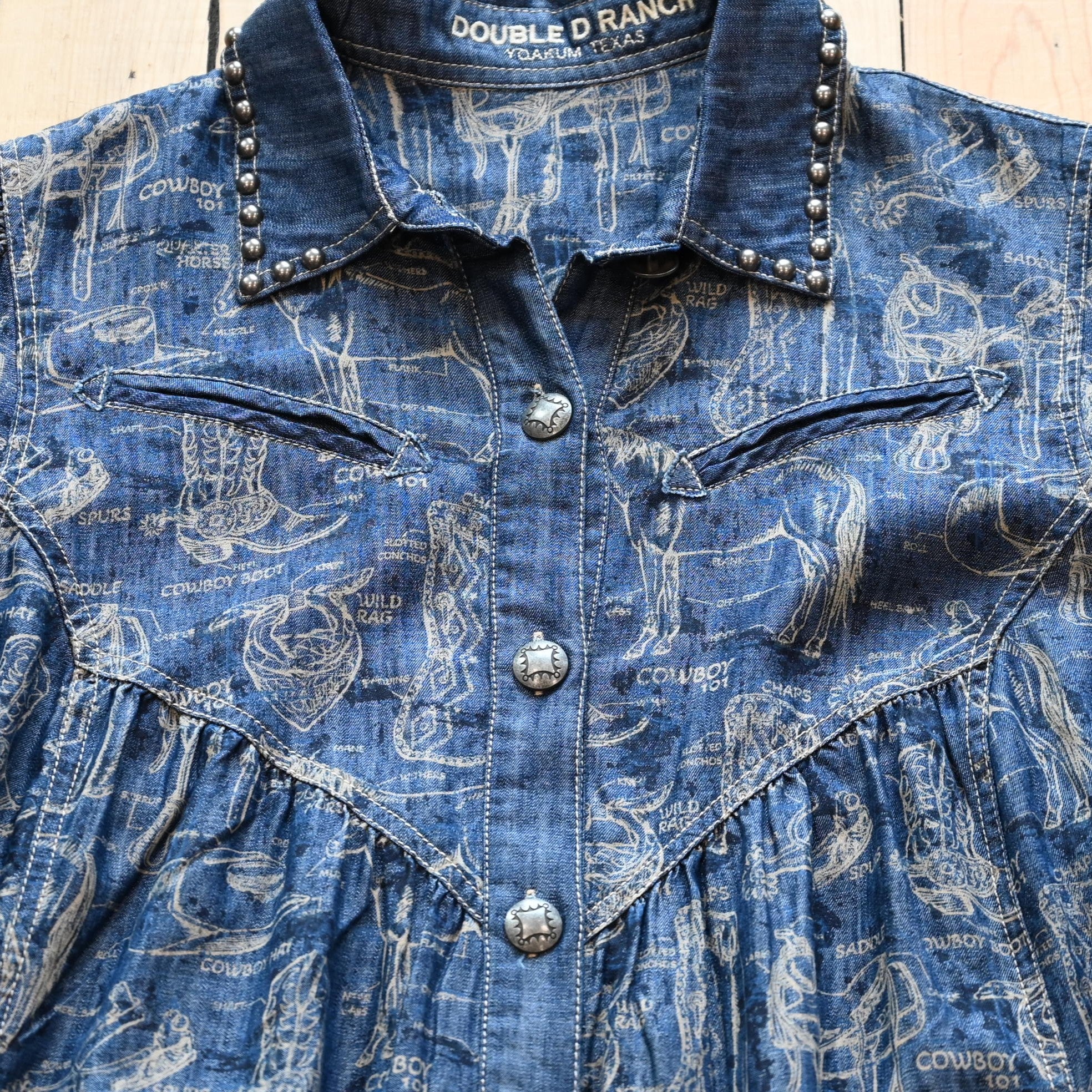 View of Double D Ranch Cowboy 101 Dress – Denim-inspired dress featuring cowboy motifs, silver studding, and concho buttons for a chic Western look