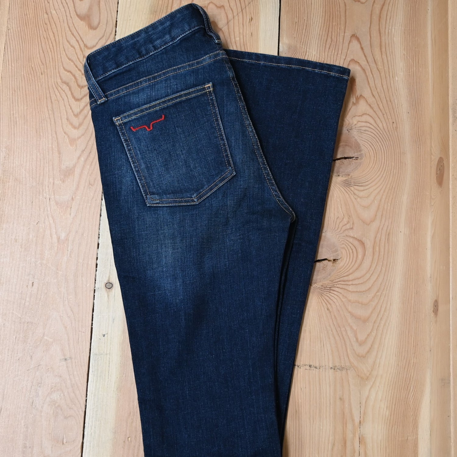View of Kimes Ranch Chloe Jeans in Blue, featuring a mid-rise waist, fitted thigh, and flare bootcut leg with hand-sanded details