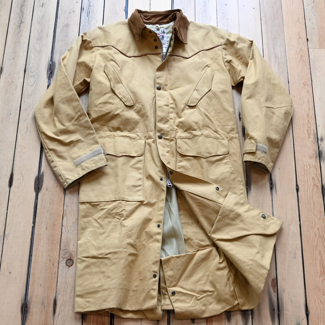 View of Schaefer canvas duster in solid suntan with corduroy collar and full-length storm flap