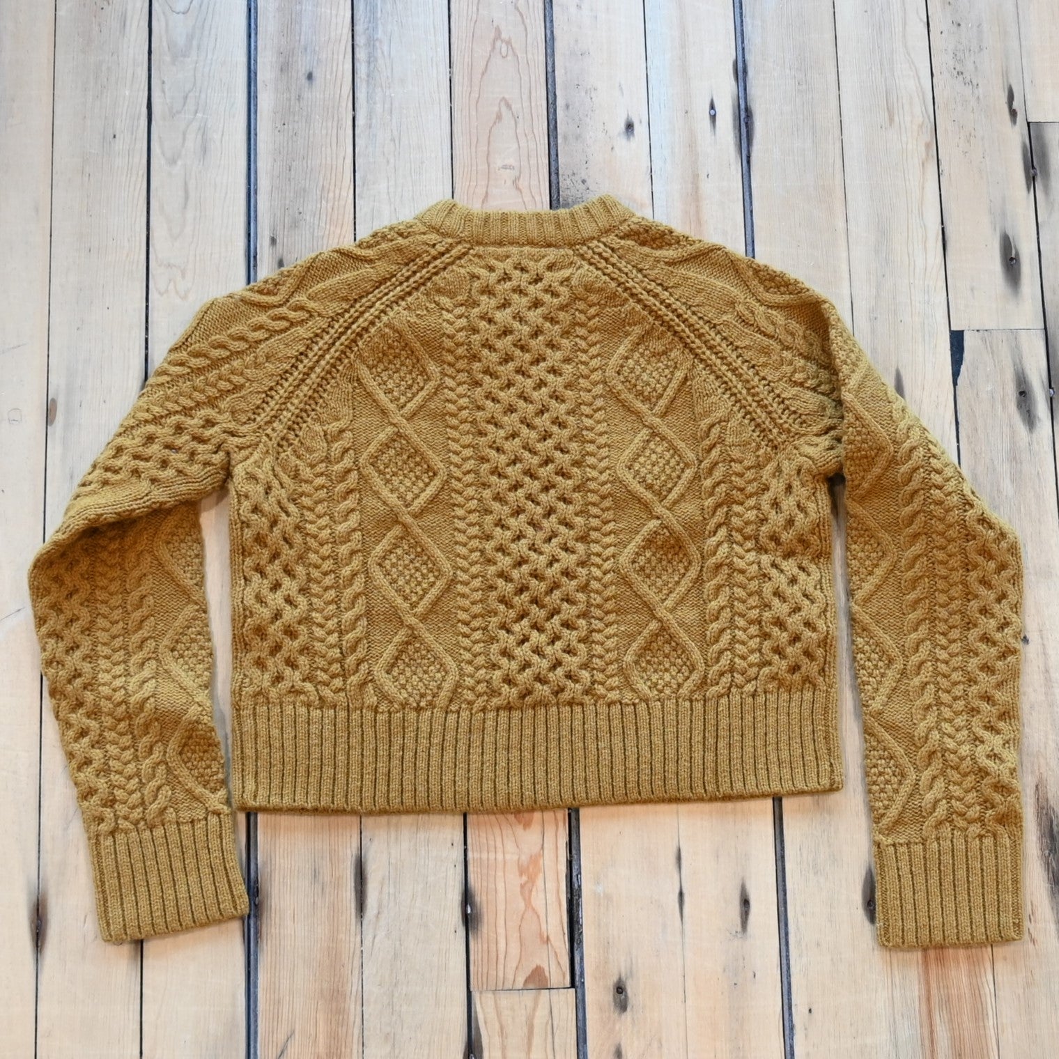 View of Pendleton cropped lambswool sweater in Deep Gold with cable knit pattern