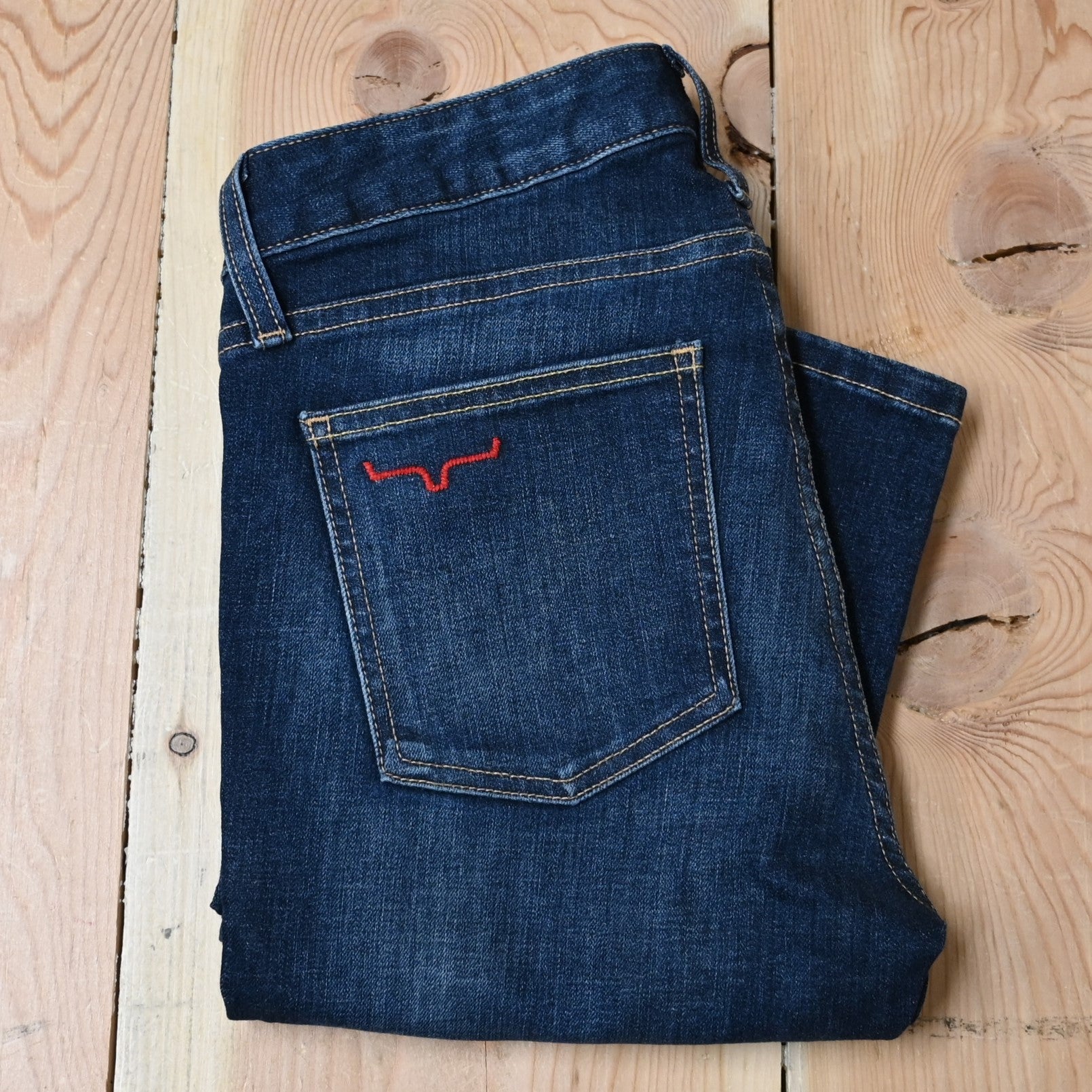 View of Kimes Ranch Chloe Jeans in Blue, featuring a mid-rise waist, fitted thigh, and flare bootcut leg with hand-sanded details