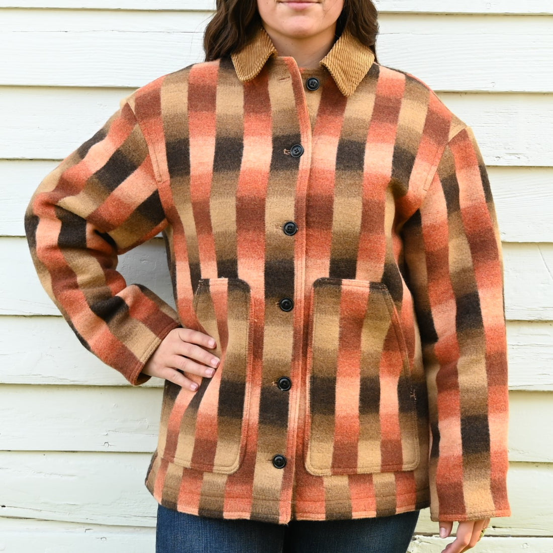View of Filson ladies blanket wool barn coat in sunset ombre featuring snap-secure pockets and a cozy wool blend