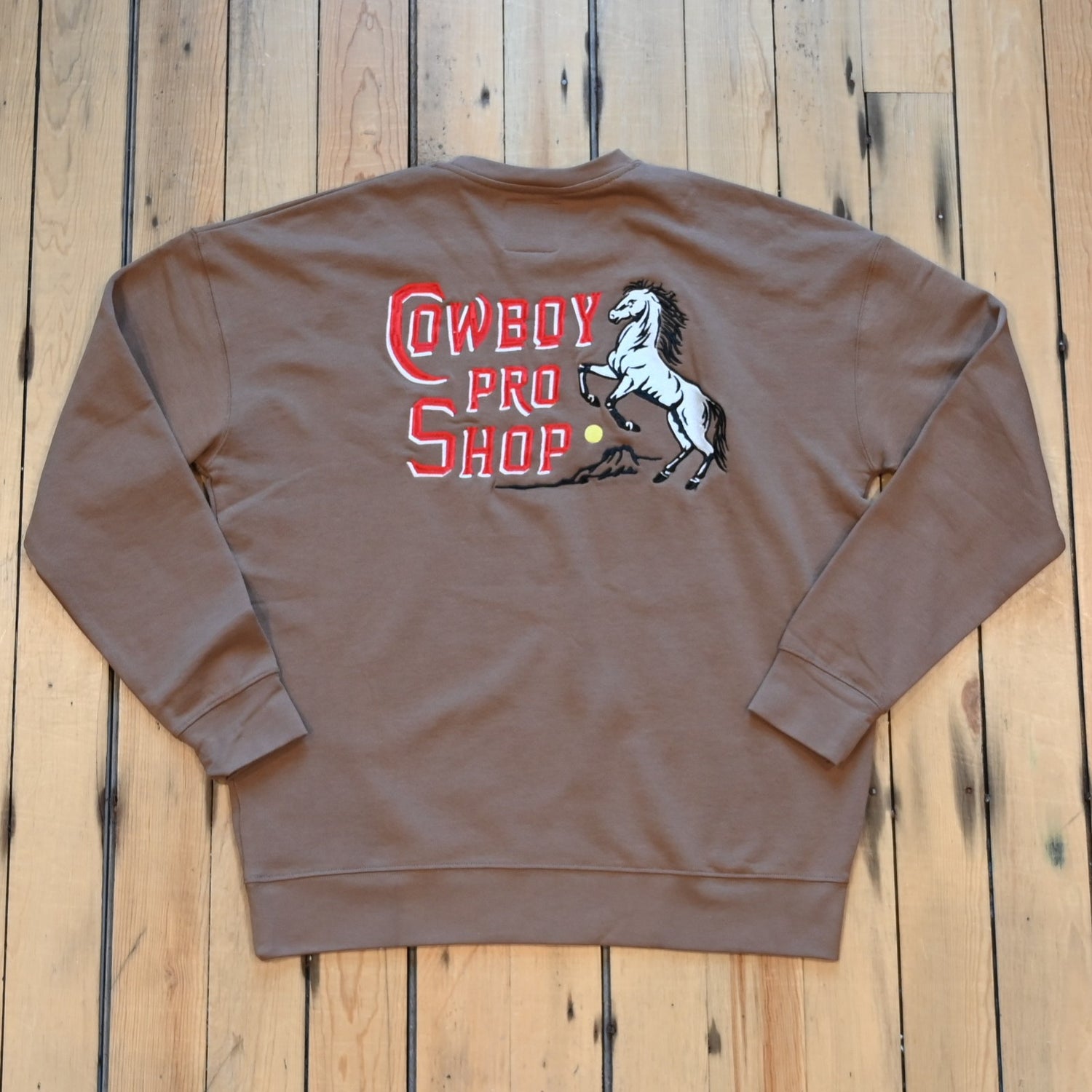 Crewneck sweatshirt with “Cowboy Pro Shop” and horse silhouette graphic in Western style