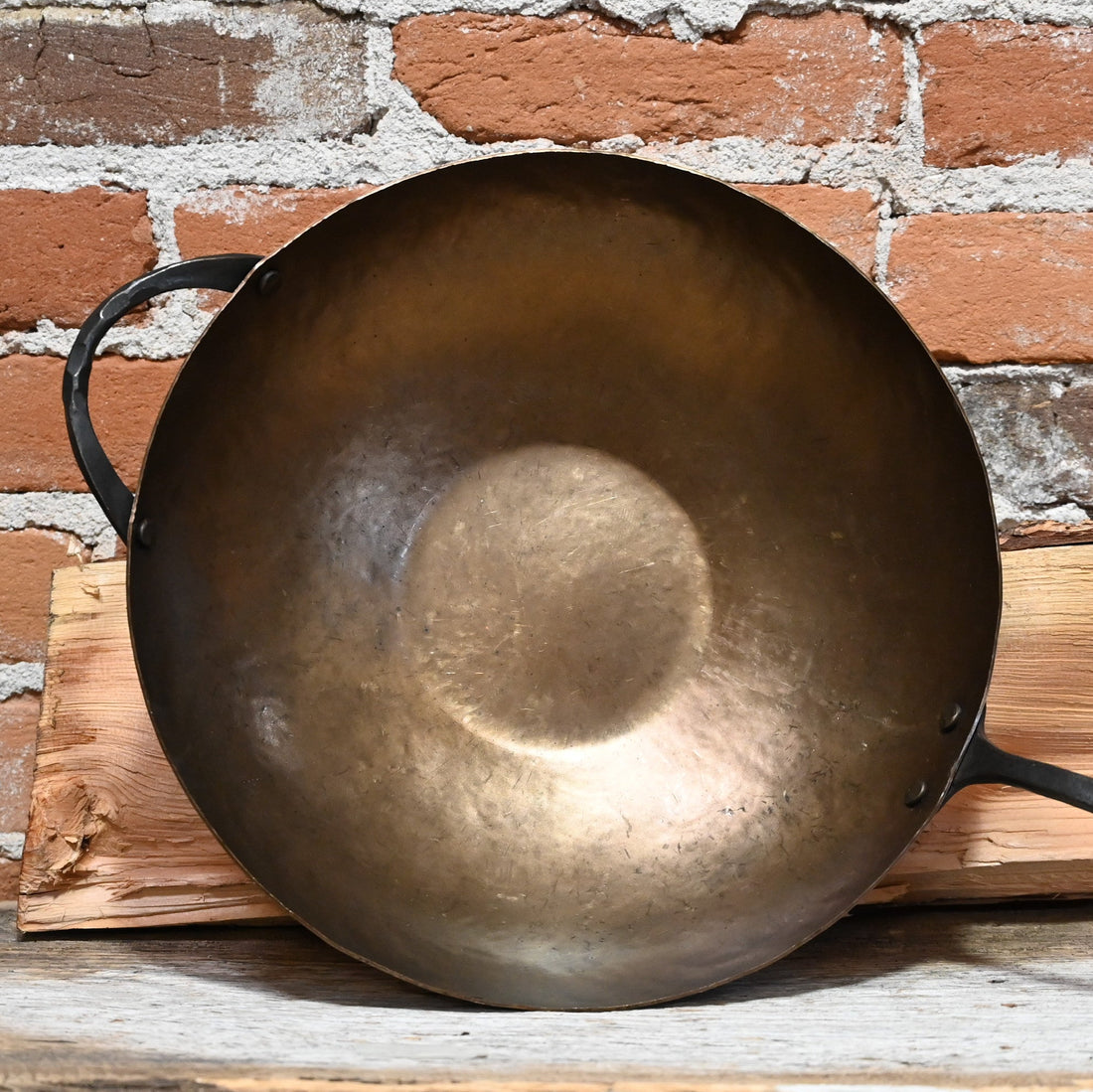 View of Smithey Ironware Carbon Steel Wok with hand-hammered surface and gooseneck handle