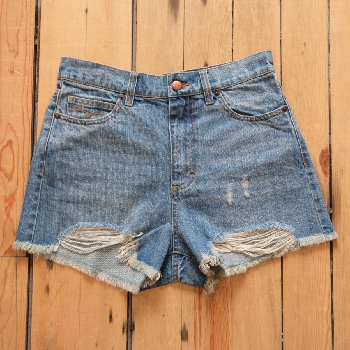 Kimes Ranch Daisy high-rise denim shorts in medium wash with raw hem.